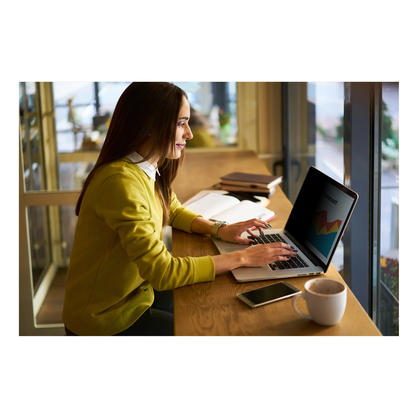 Femme utilisant un ordinateur portable avec filtre de confidentialité 3M dans un café, vue de côté