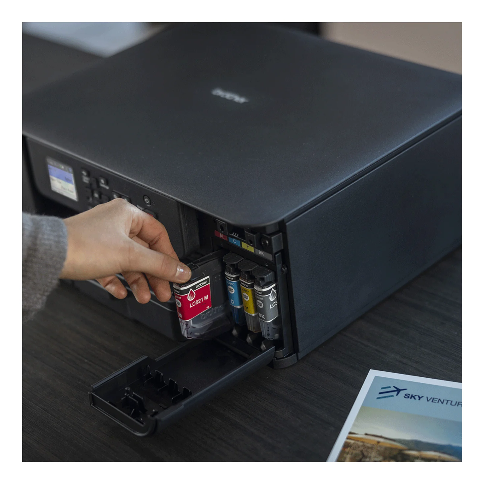Vue plongeante du dessus de l'imprimante Brother DCP-J1310DW avec capot scanner fermé et logo brother