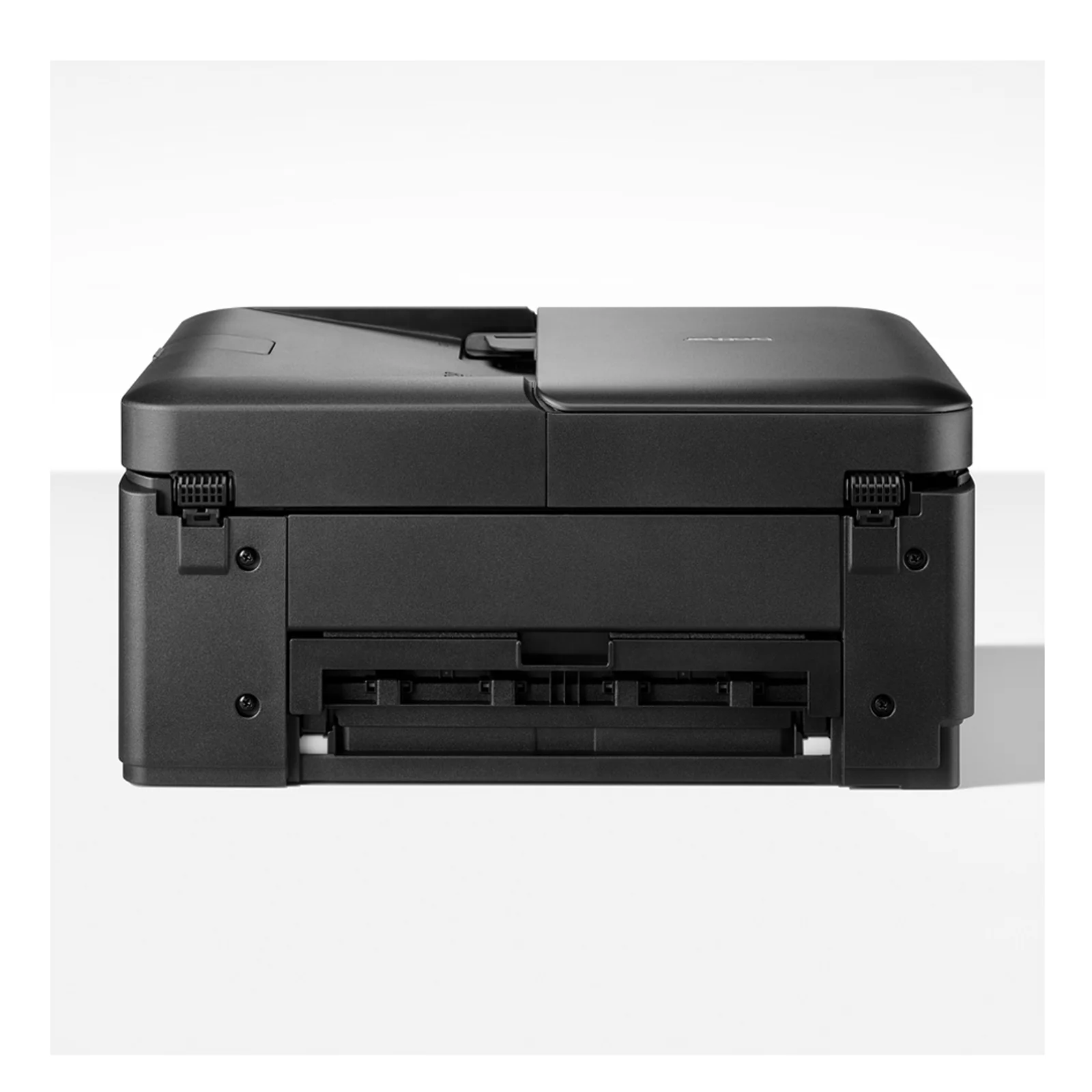 Imprimante Brother DCP-J1460DW posée dans un bureau lumineux avec papier multifonction visible