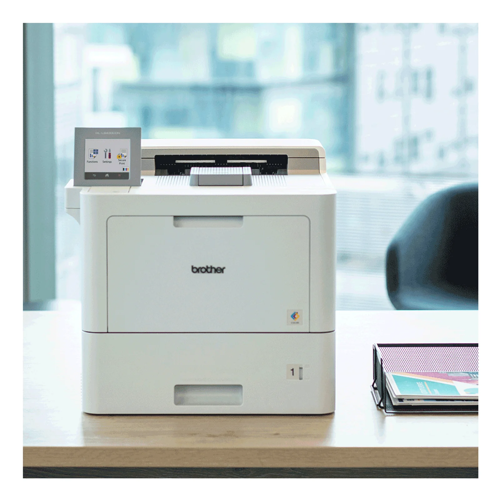 Imprimante laser Brother HL-L9470CDN posée sur un bureau clair avec chaise en arrière-plan et fenêtre lumineuse en environnement professionnel