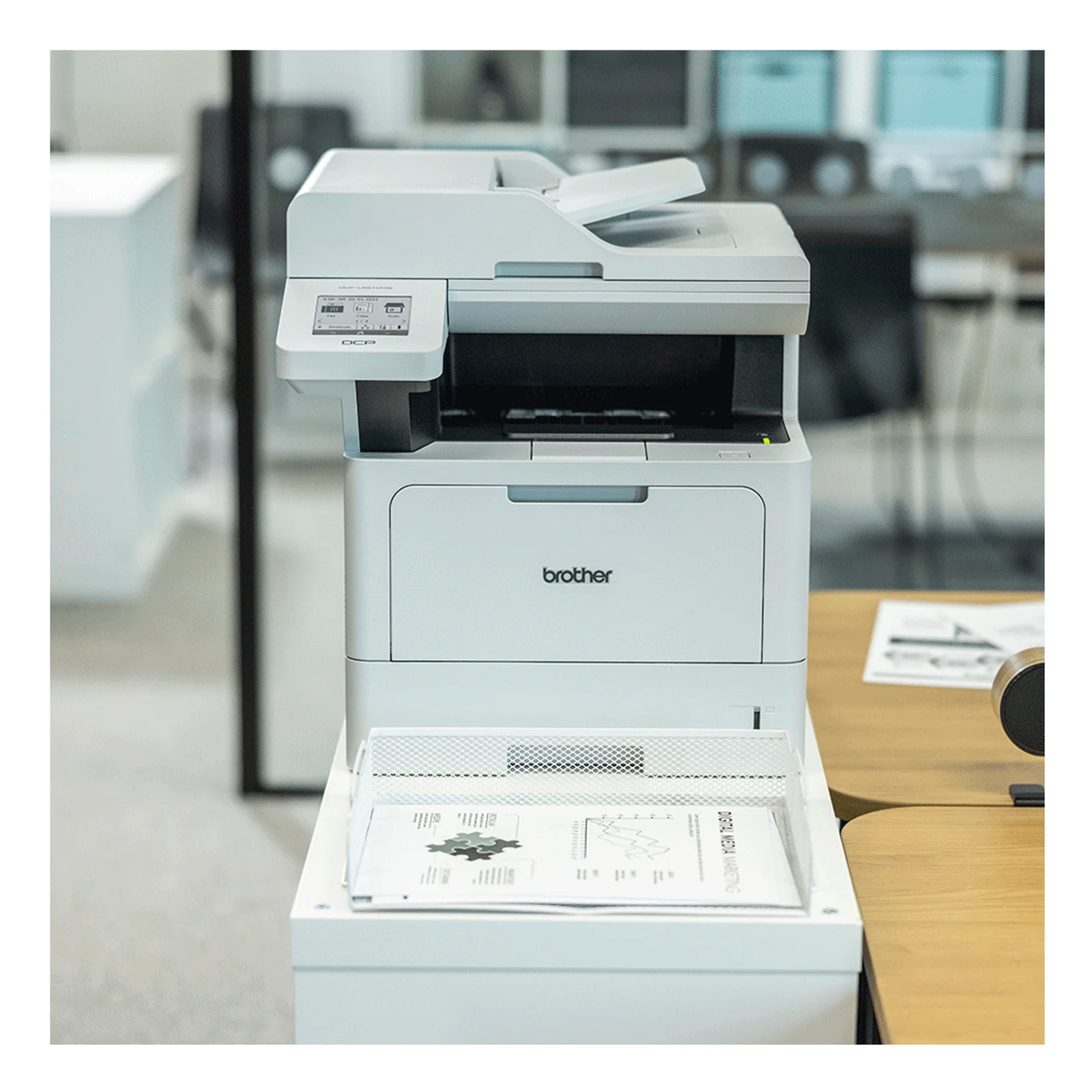Multifonction Brother posé sur un meuble blanc dans un bureau lumineux avec documents