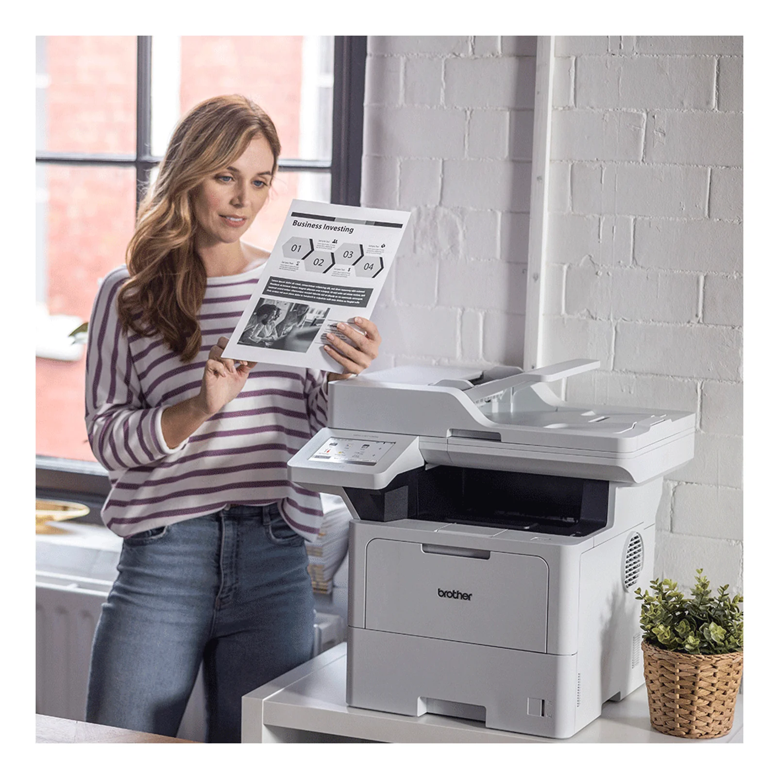 Femme dans un bureau lumineux consultant un document imprimé à côté du multifonction Brother MFC-L6710DW posé sur un meuble