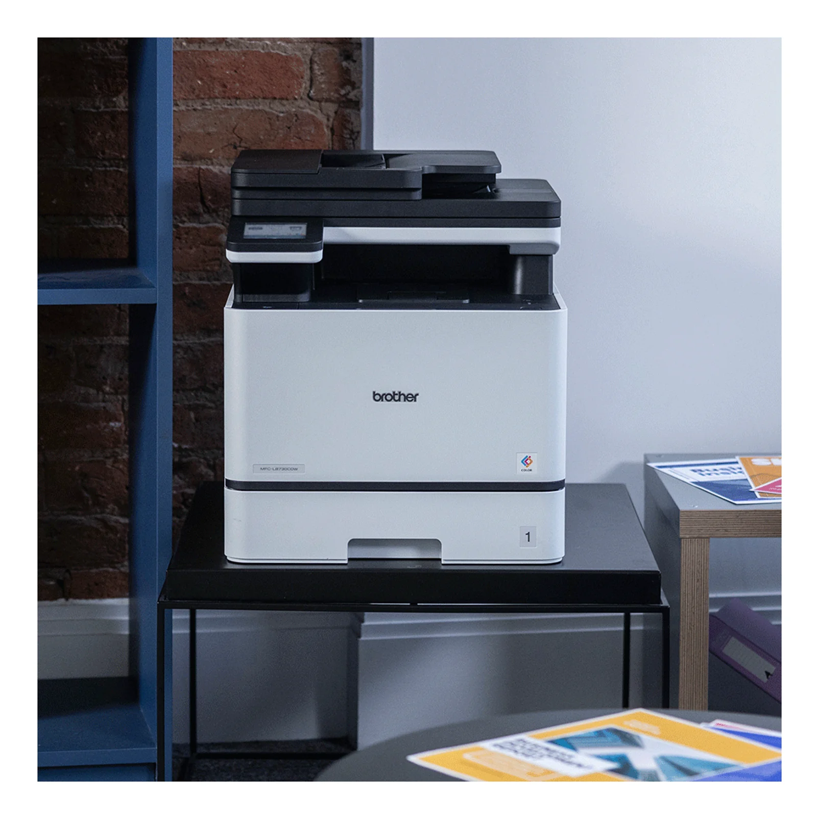 Brother MFC-L8730CDW de face avec impression A4 couleur sortie sur le plateau supérieur, étiquette modèle visible