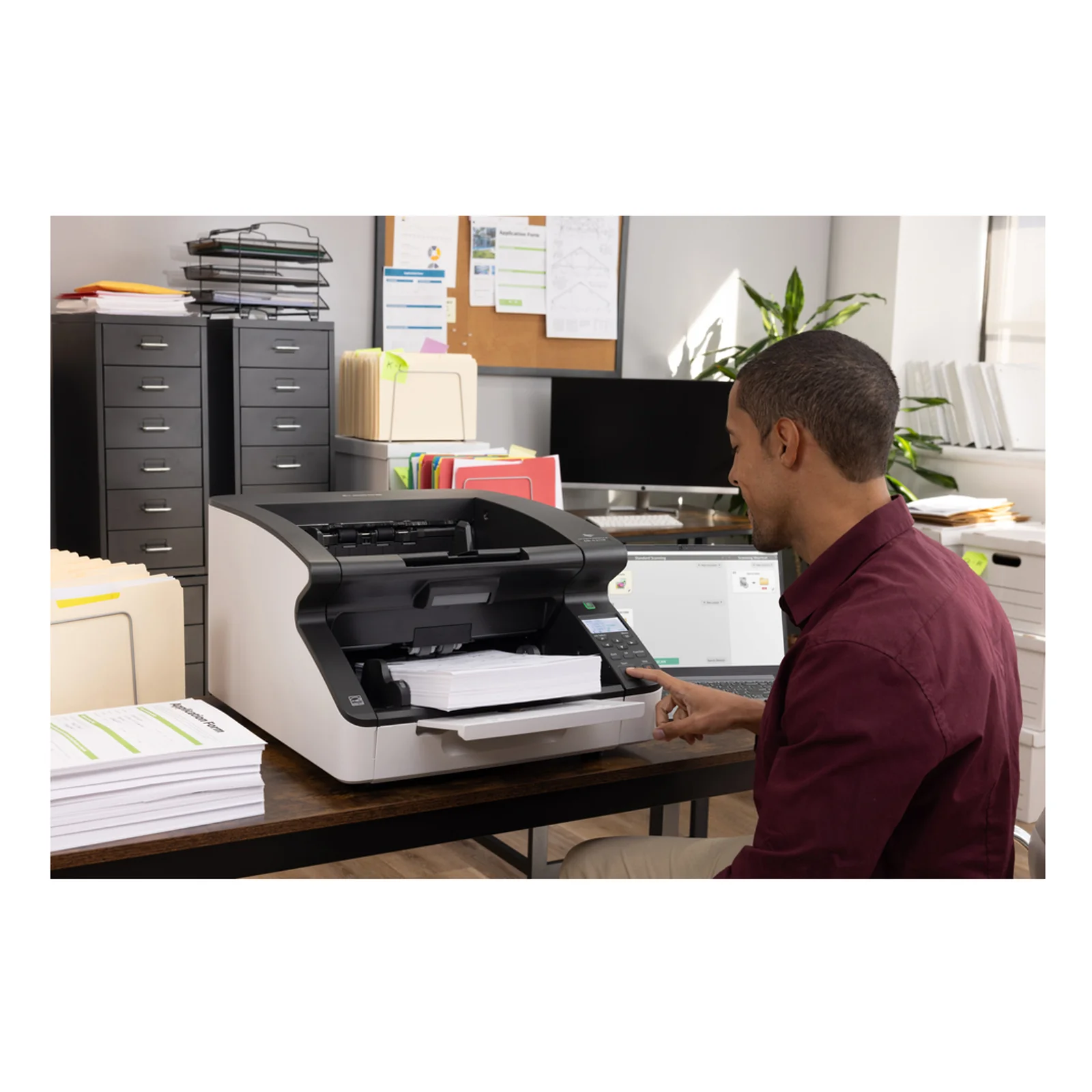 Canon DR-G2110 vu de face dans un bureau avec bac d'éjection déployé et armoires d'archivage en arrière-plan