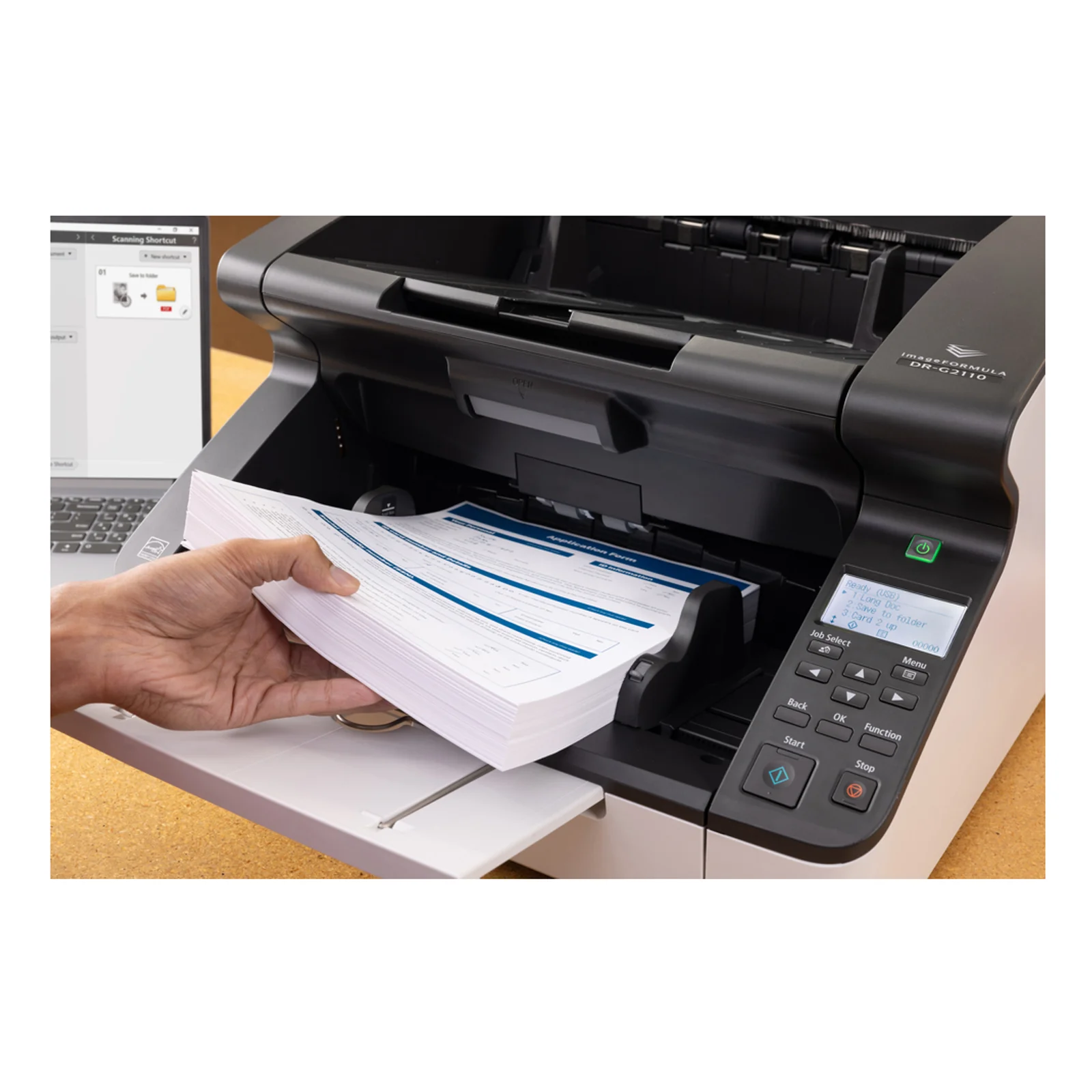 DR-G2110 en utilisation main posant une pile épaisse de formulaires bleus dans le chargeur 500 feuilles