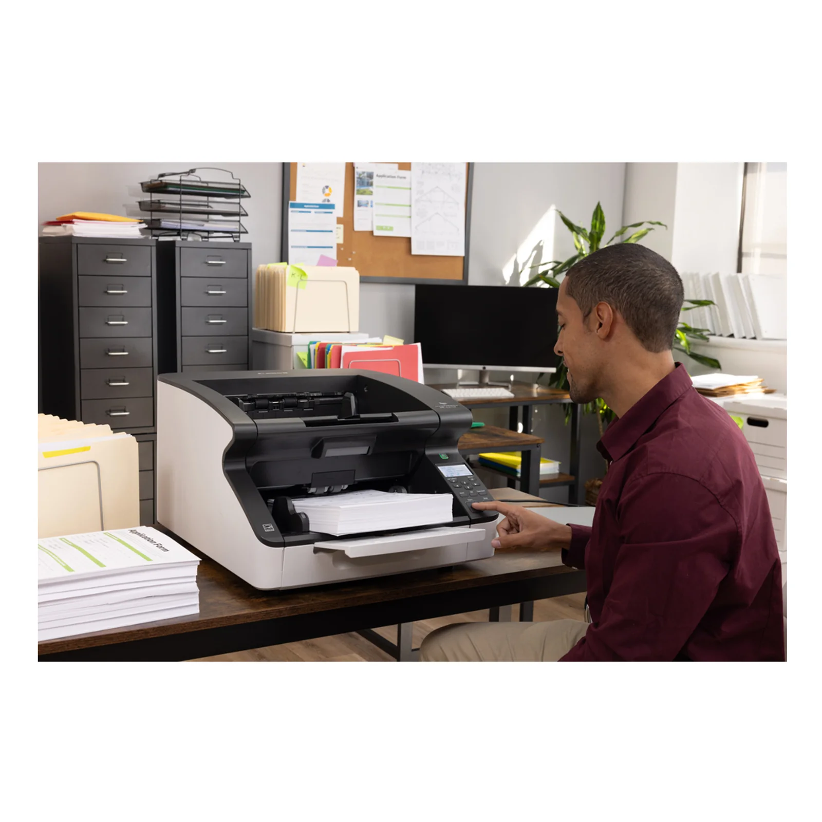 Scanner DR-G2110 dans une salle d'archivage avec armoires métalliques et opérateur en chemise bordeaux à proximité