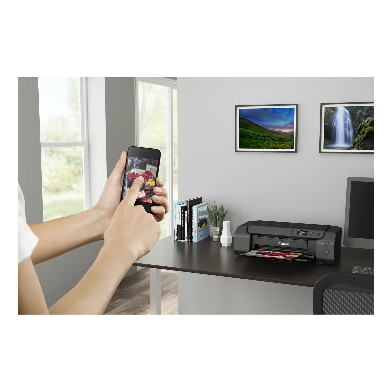 Mains avec smartphone affichant des fleurs face à la PRO-200S imprimant un tirage couleur