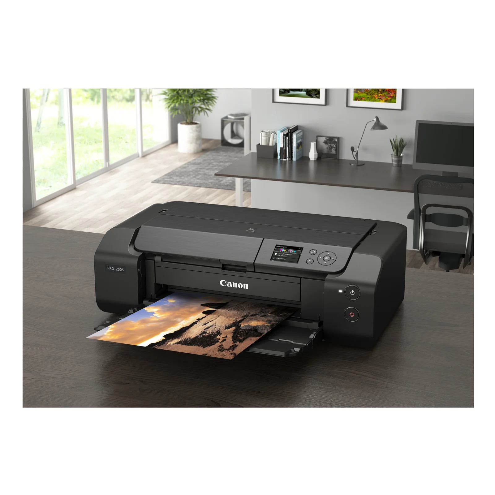 Canon PIXMA PRO-200S installée sur un bureau bois avec tirage paysage et décoration sur le mur