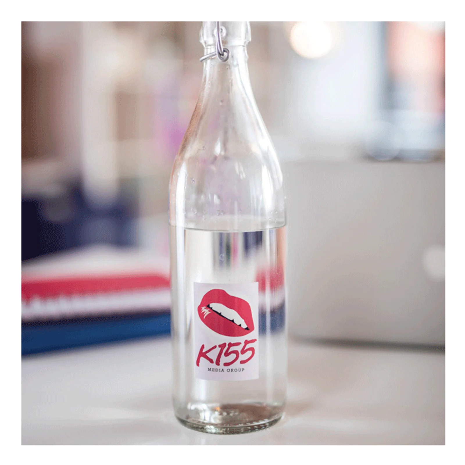 Bouteille en verre transparente avec étiquette personnalisée K155 lèvres rouges sur un bureau