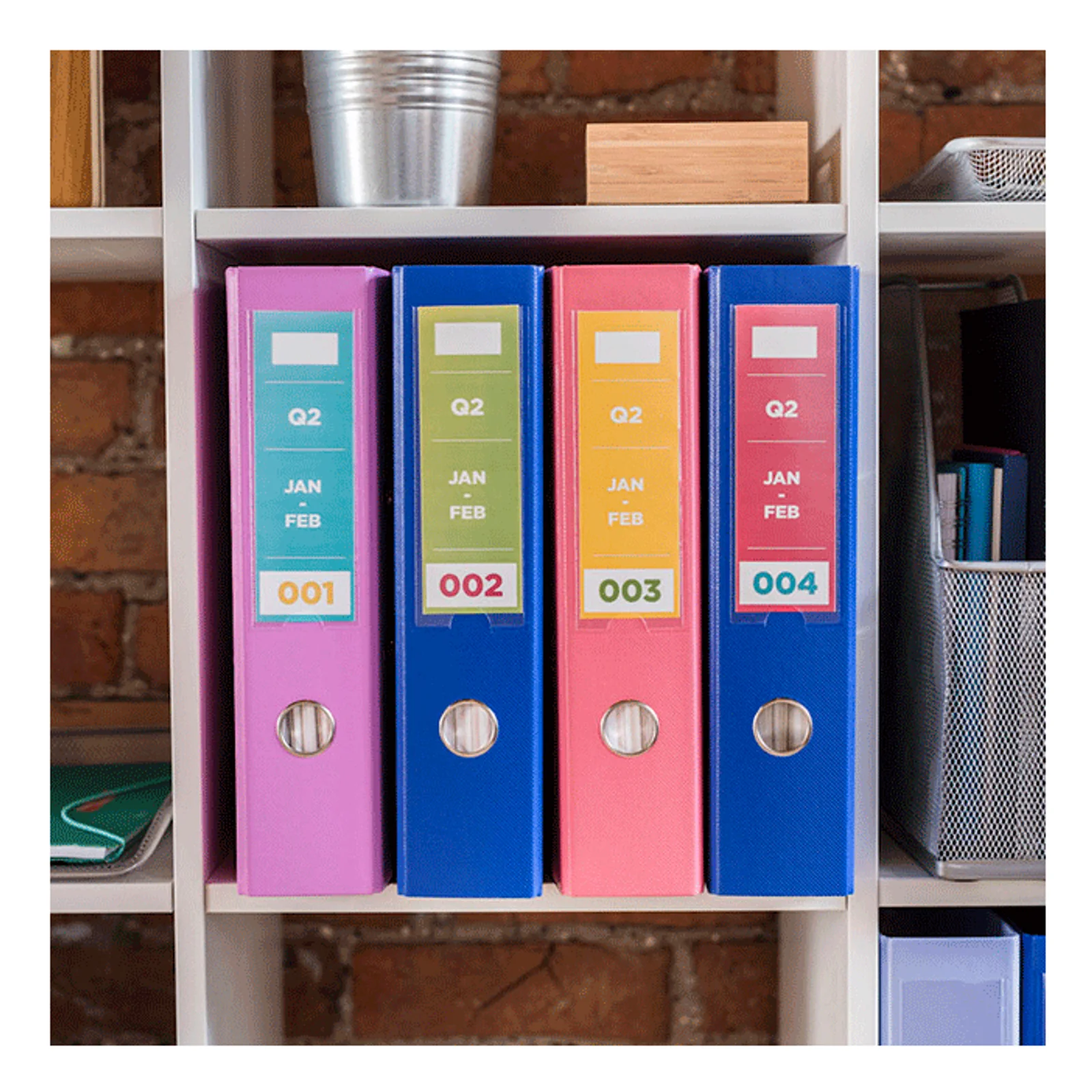 Quatre classeurs colorés rose bleu et corail rangés sur étagère avec étiquettes Q2 imprimées