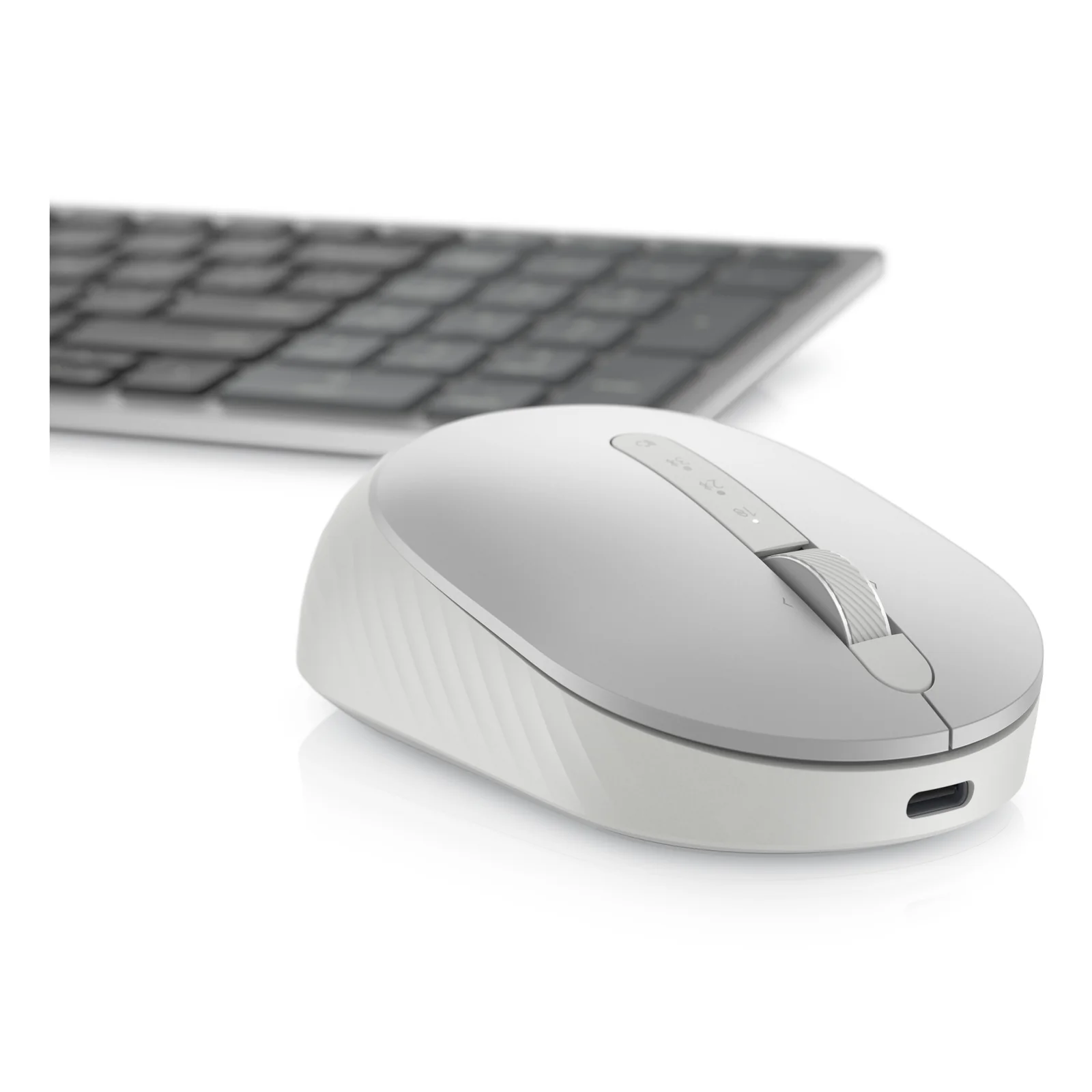 Souris argentée mise en scène devant un clavier sombre flou en arrière-plan