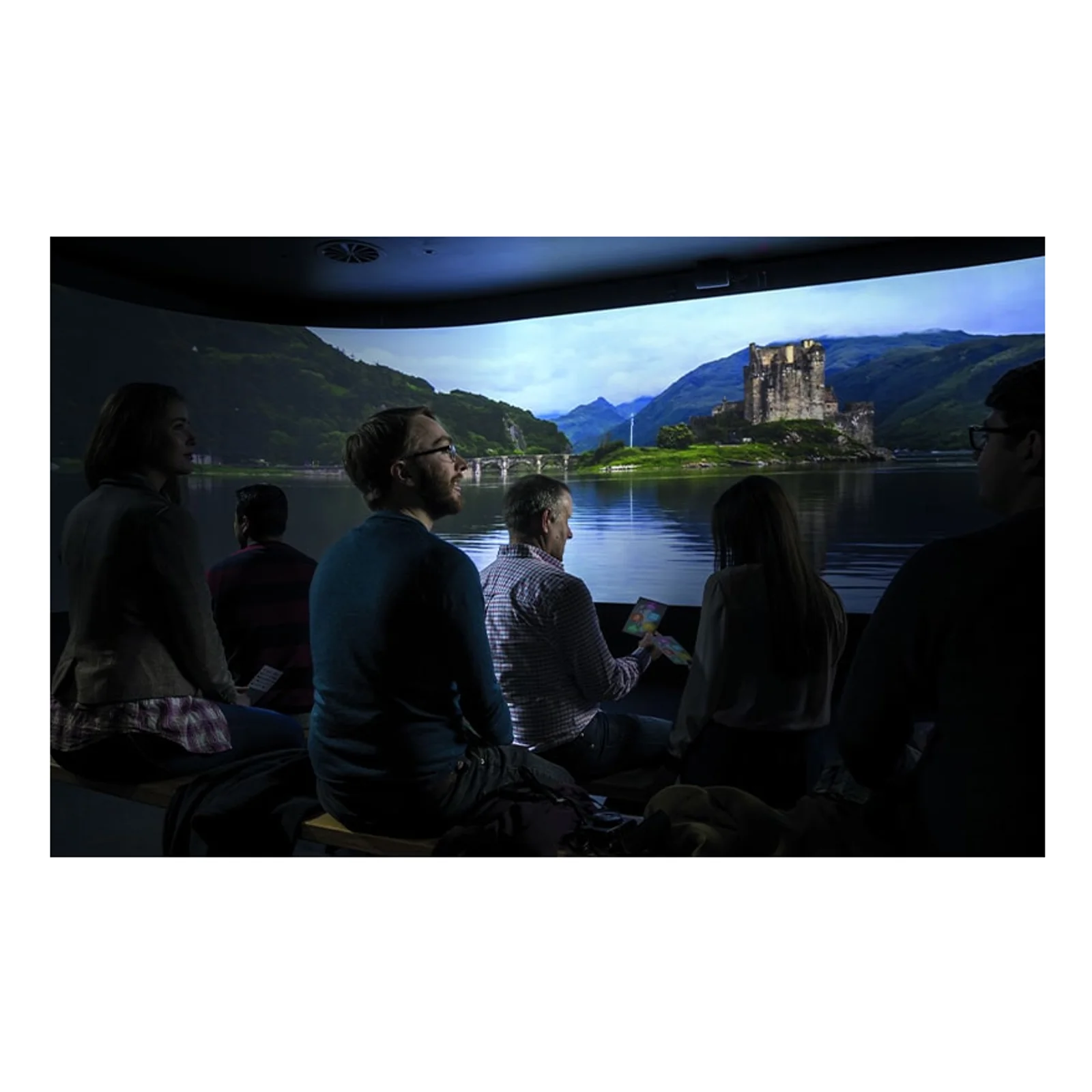 Salle immersive incurvée projetant un paysage de château écossais