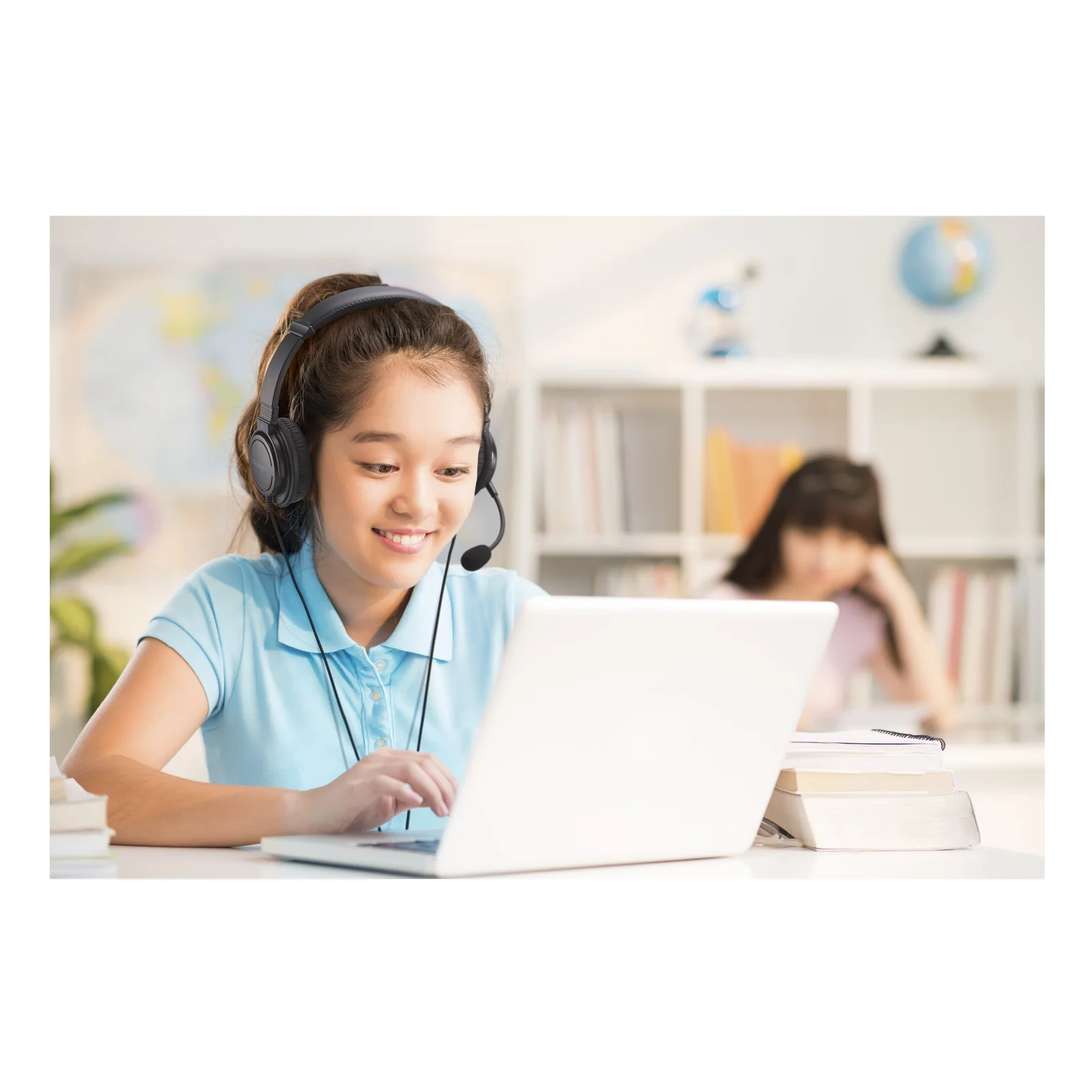 Écolière portant un micro-casque Kensington USB-C devant un laptop en classe