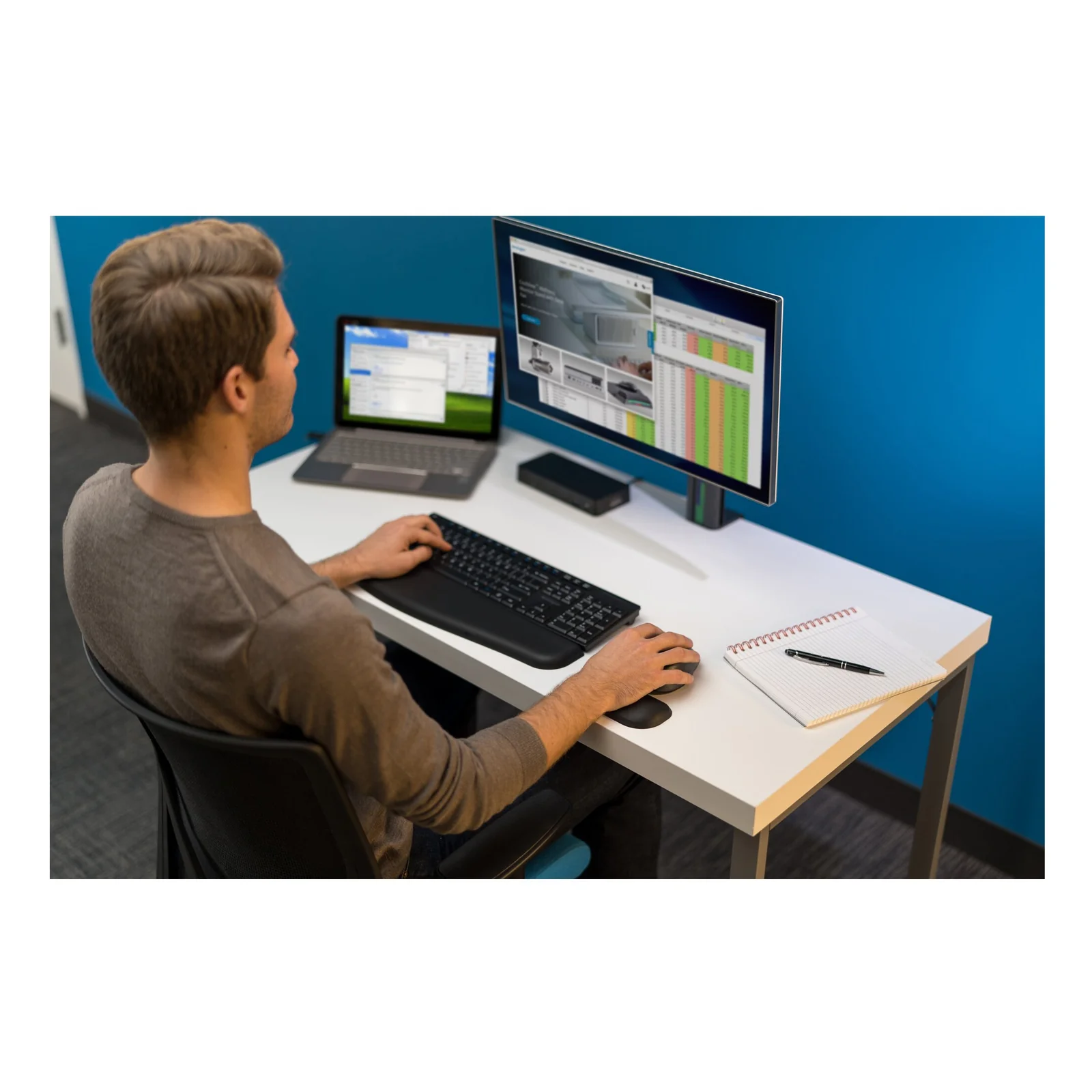Homme en open space, double écran, clavier et souris avec repose-poignet Kensington