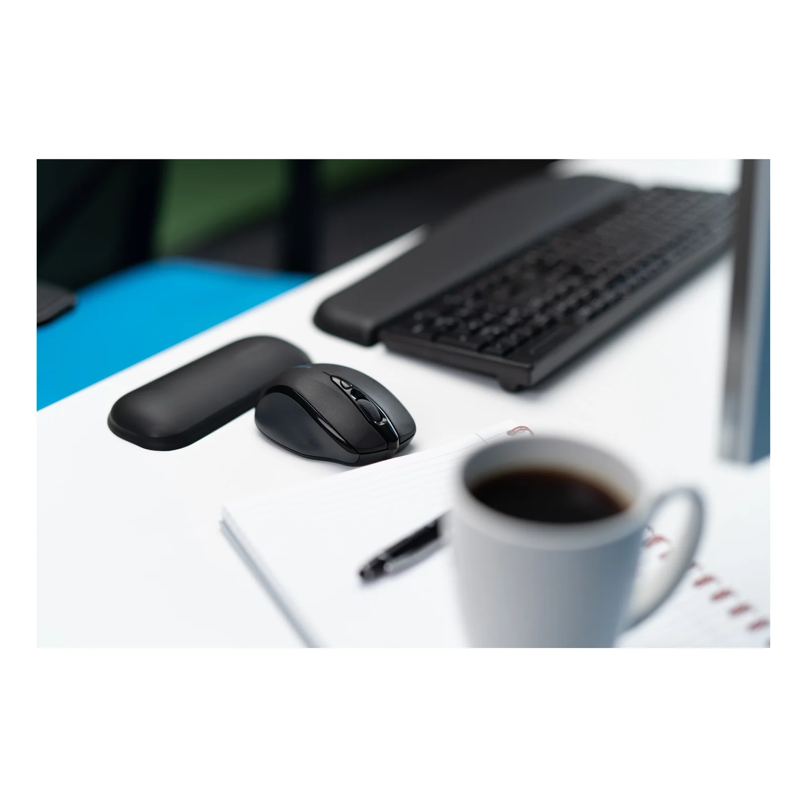 Souris sans fil et repose-poignet Kensington ErgoSoft noir posés sur bureau, café à côté