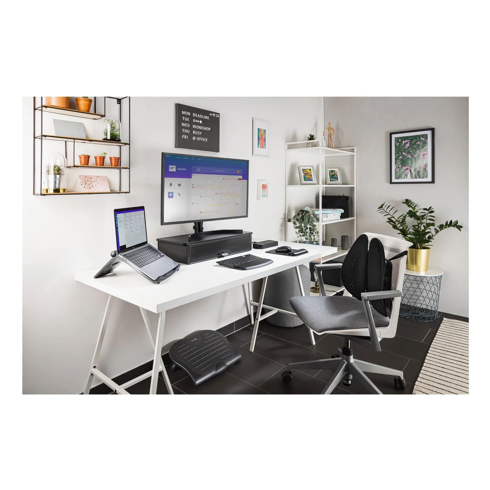 Bureau à domicile avec écran, ordinateur portable sur support réglable, souris et accessoires, ambiance lumineuse