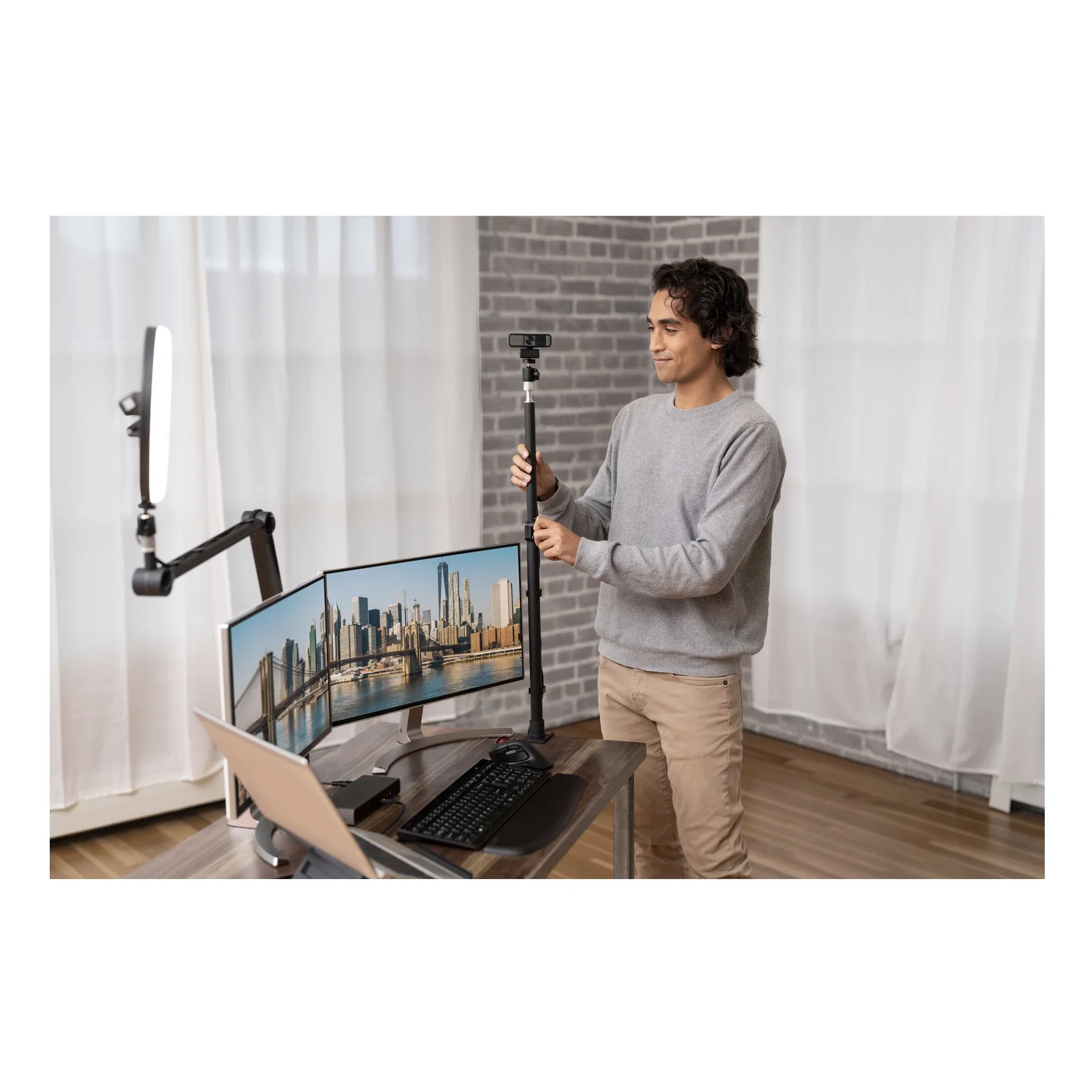 Homme debout réglant un écran sur bureau assis-debout, configuration multi-moniteurs