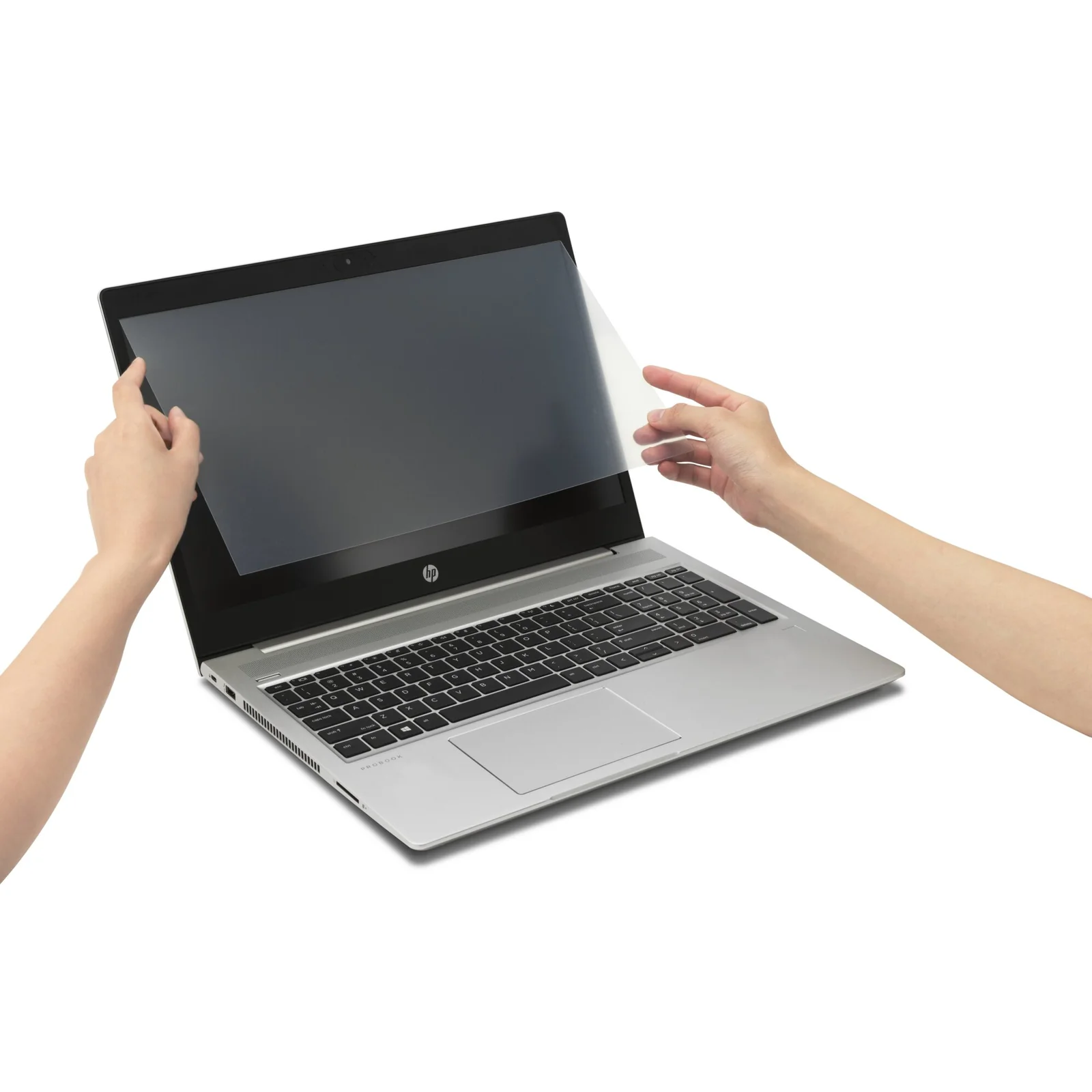 Deux mains tenant le filtre antireflet Kensington au-dessus d'un laptop HP argenté ouvert