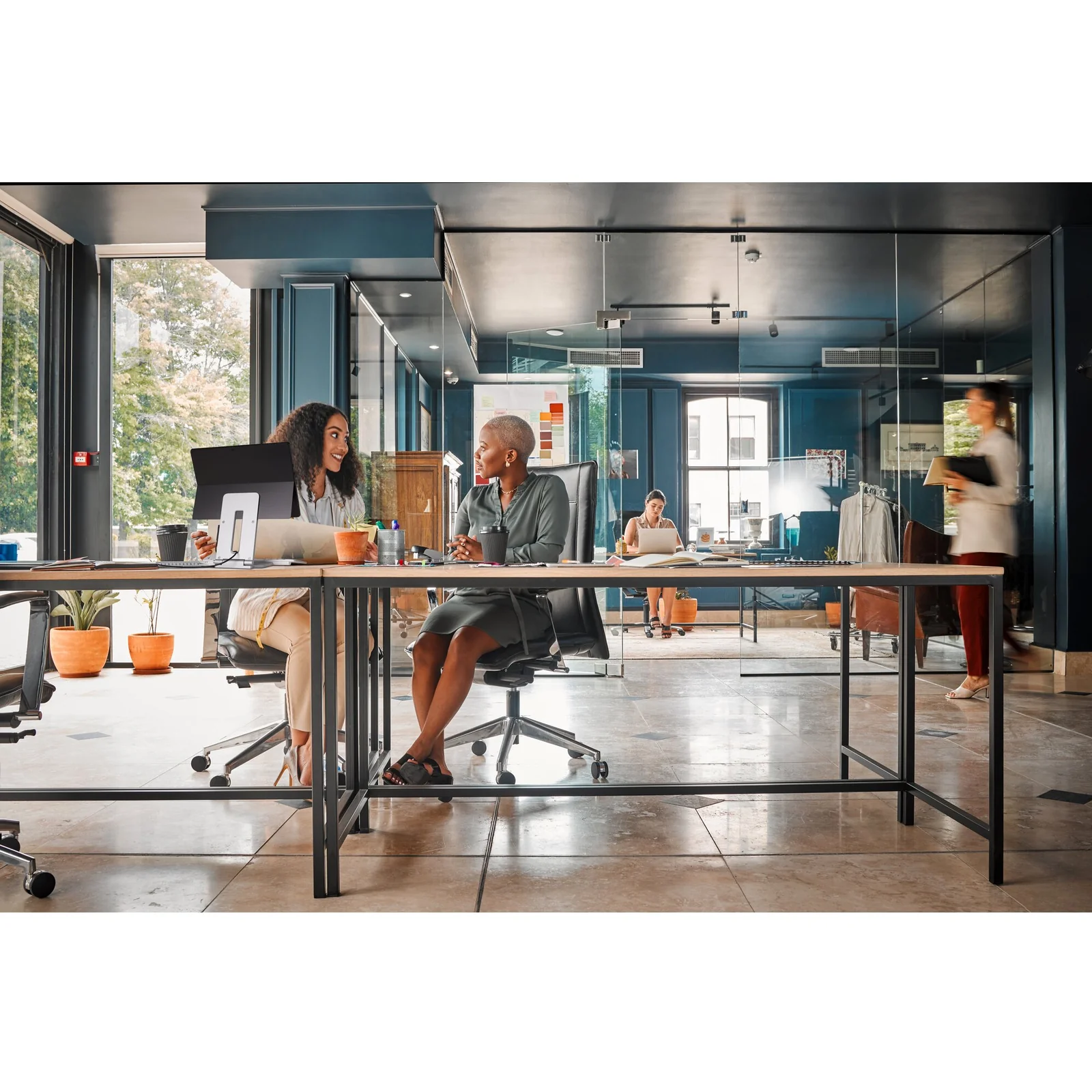 Open space bureau moderne avec baies vitrées, équipe travaillant sur ordinateurs