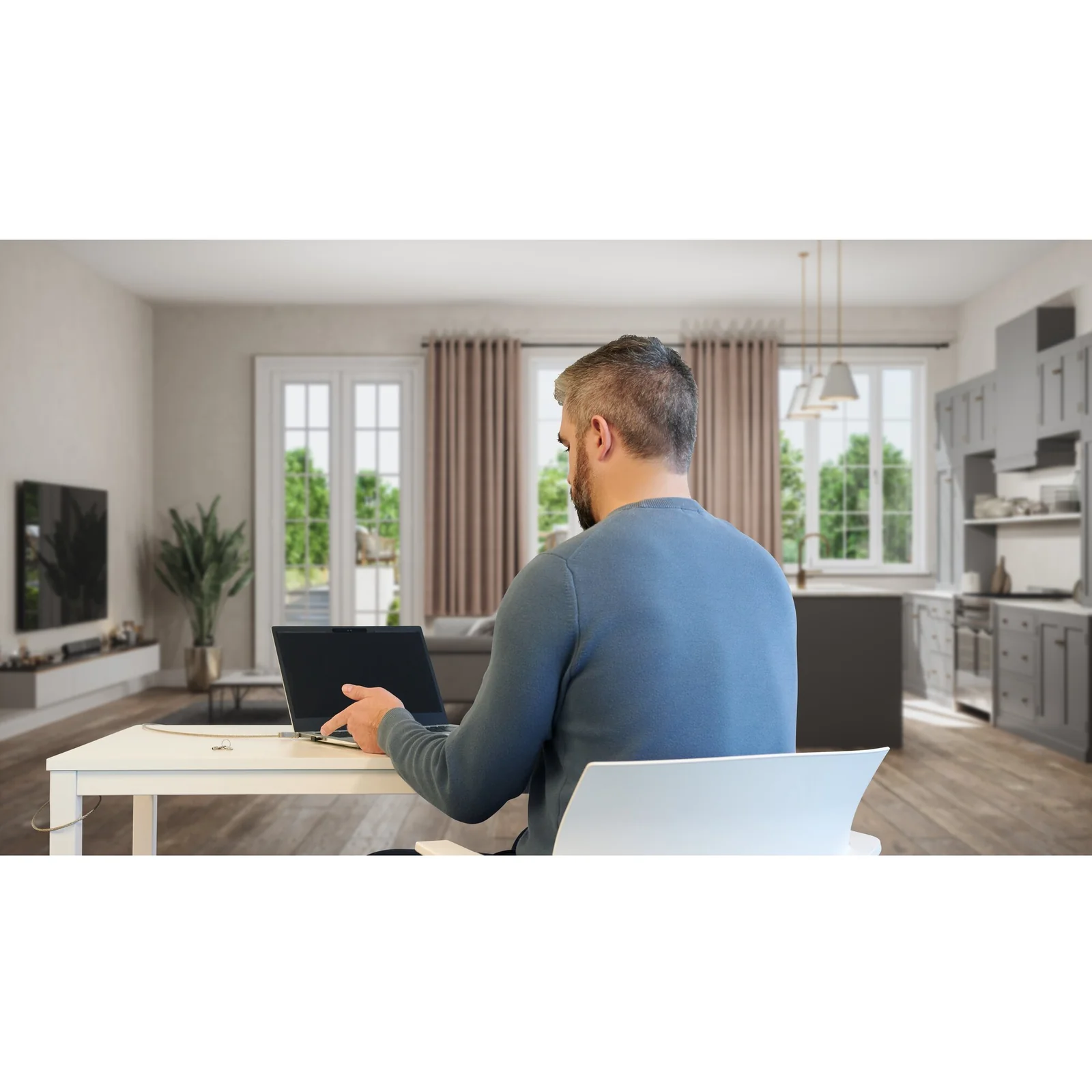Homme dans un salon, vue légèrement rapprochée, ordinateur portable ou tablette posé devant lui