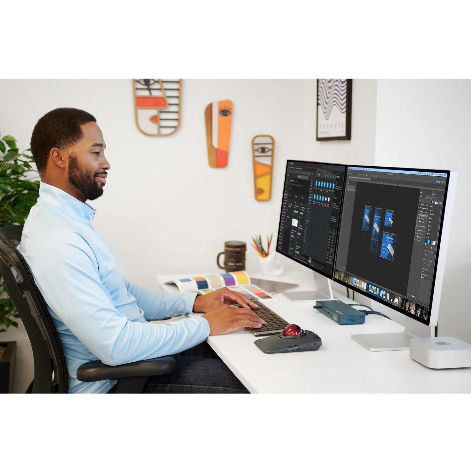 Homme au bureau face à un grand écran, KB535 EQ et souris noire Kensington sur plan de travail clair