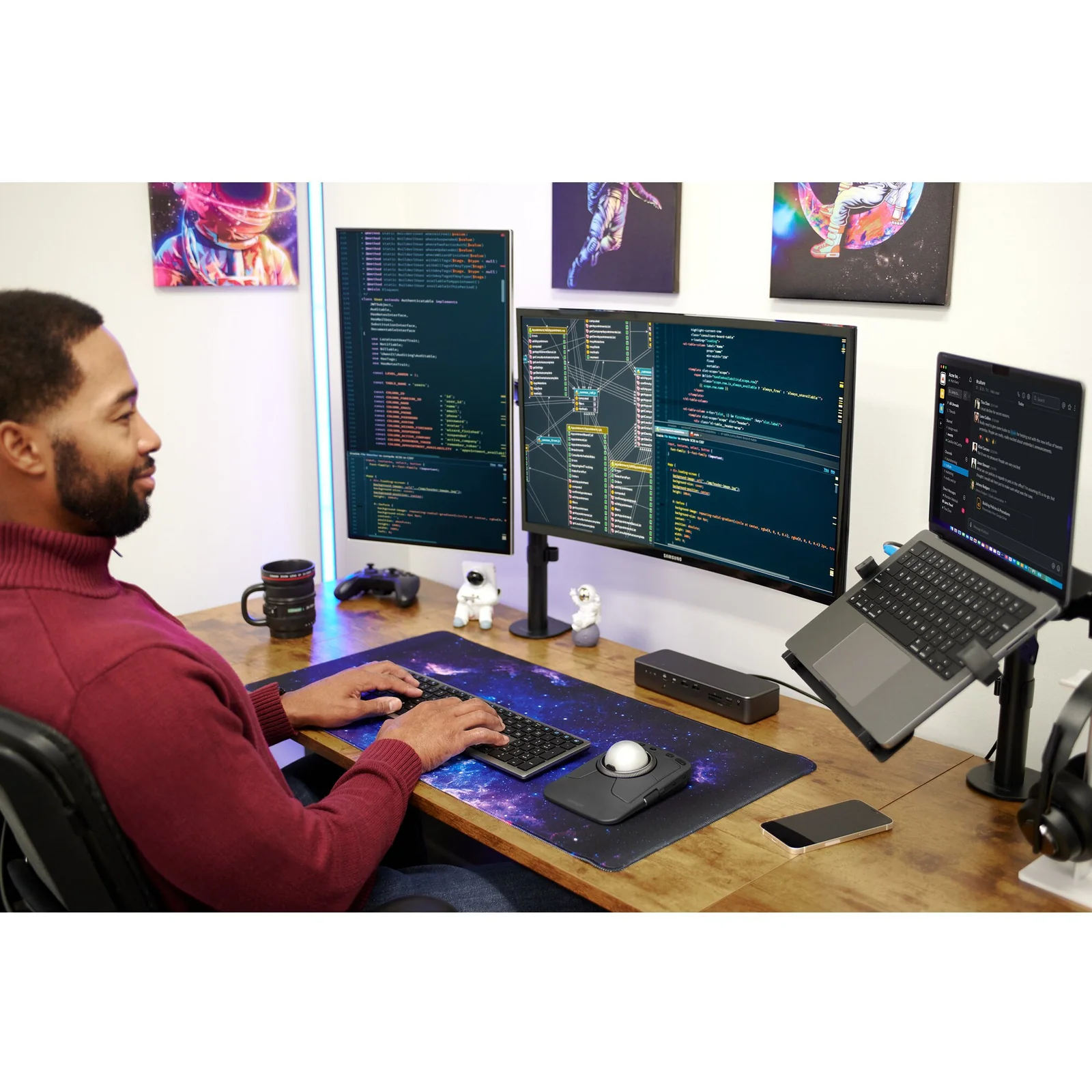 Homme face à trois moniteurs affichant du code, KB535 EQ sur bureau avec éclairage ambiant bleu