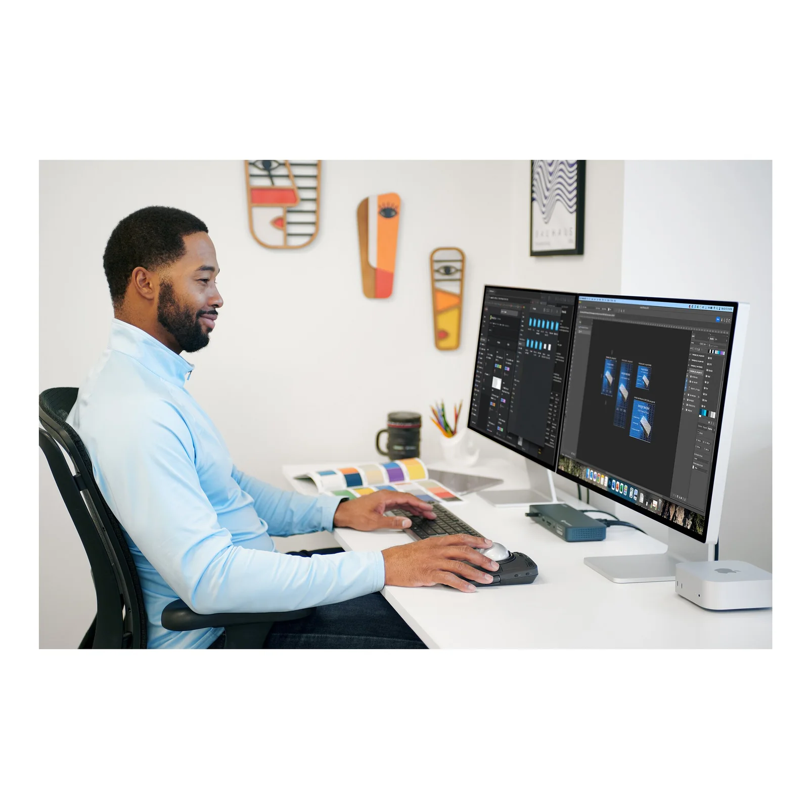 Homme travaillant sur écran large, KB535 EQ et souris Kensington sur bureau avec plante verte