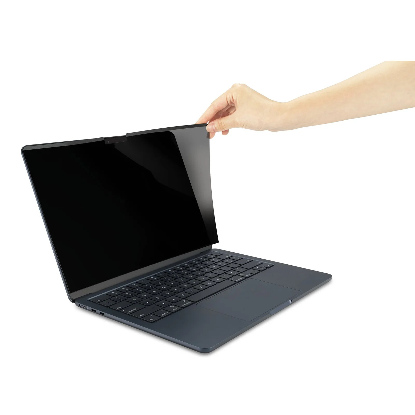 Main qui détache le filtre MagPro Elite d'un MacBook Air ouvert, vue de face