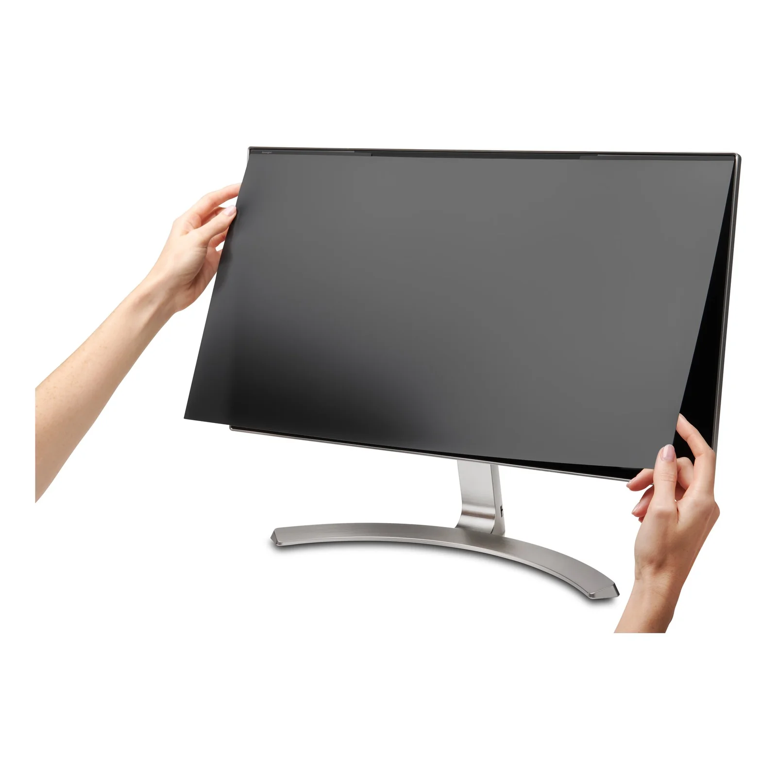Mains tenant et installant le filtre magnétique Kensington MagPro sur un moniteur blanc