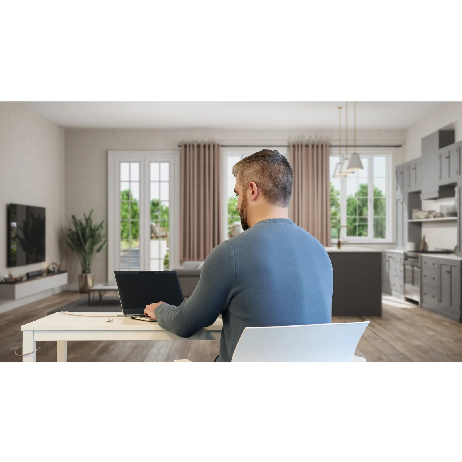 Homme travaillant sur laptop avec filtre de confidentialité depuis son salon