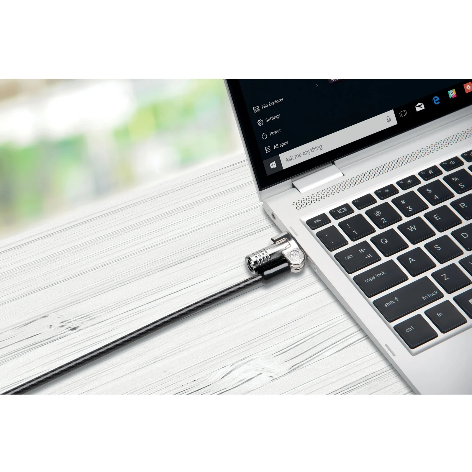 Câble NanoSaver attaché à un ordinateur portable posé sur un plan de travail clair