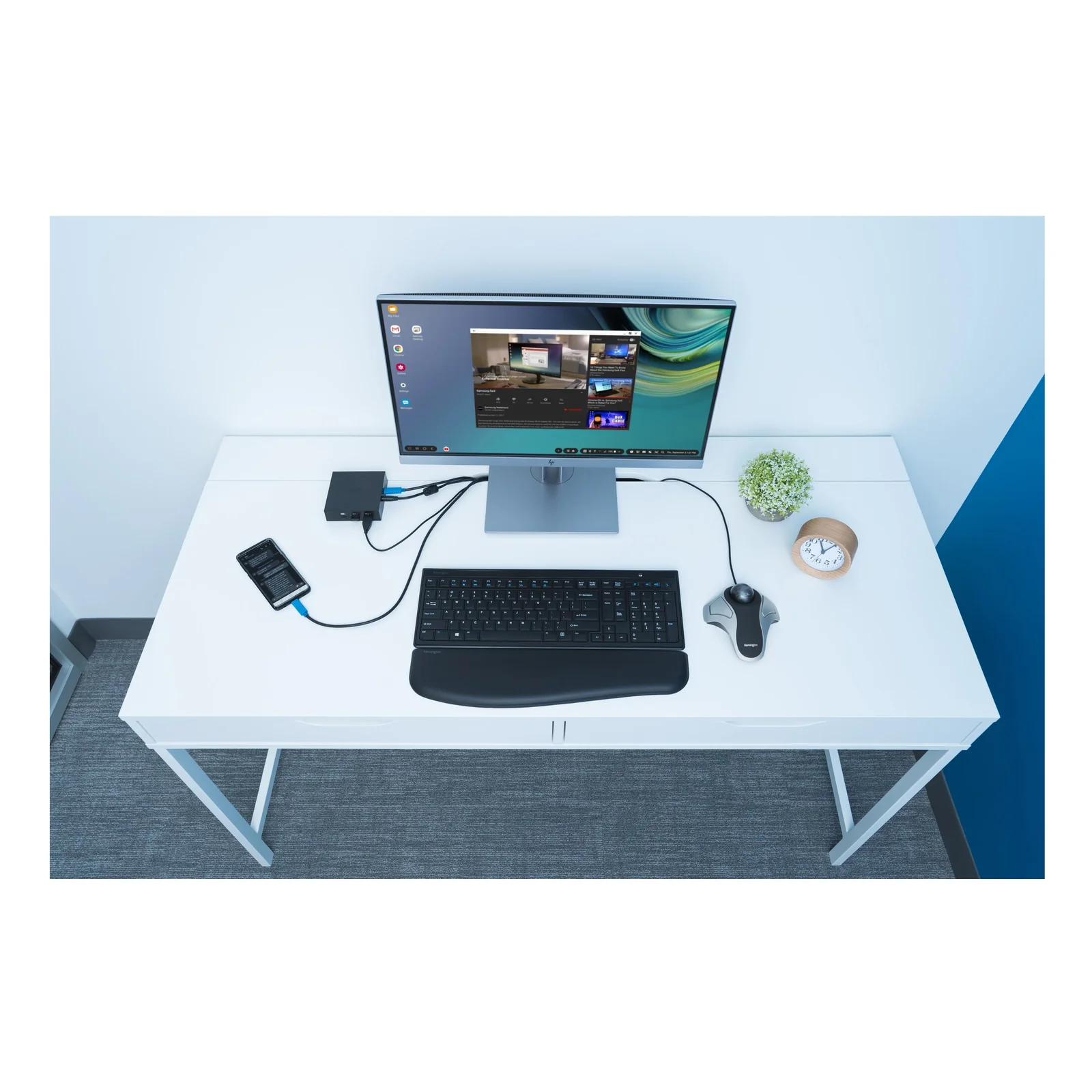 Bureau blanc avec moniteur, clavier et trackball Kensington Orbit, vue en angle de dessus