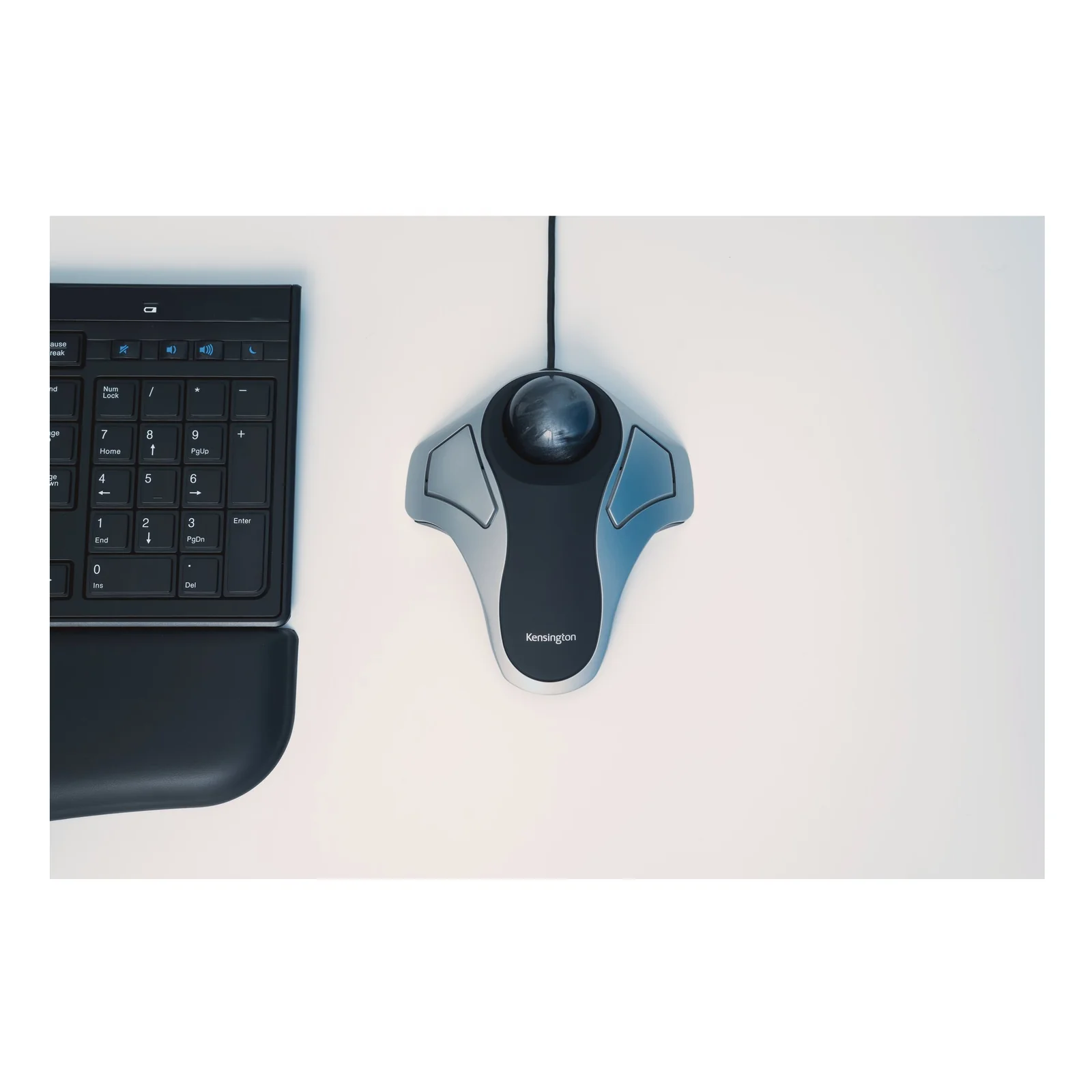 Gros plan du trackball Kensington Orbit posé près d'un clavier, boule noire et corps argenté