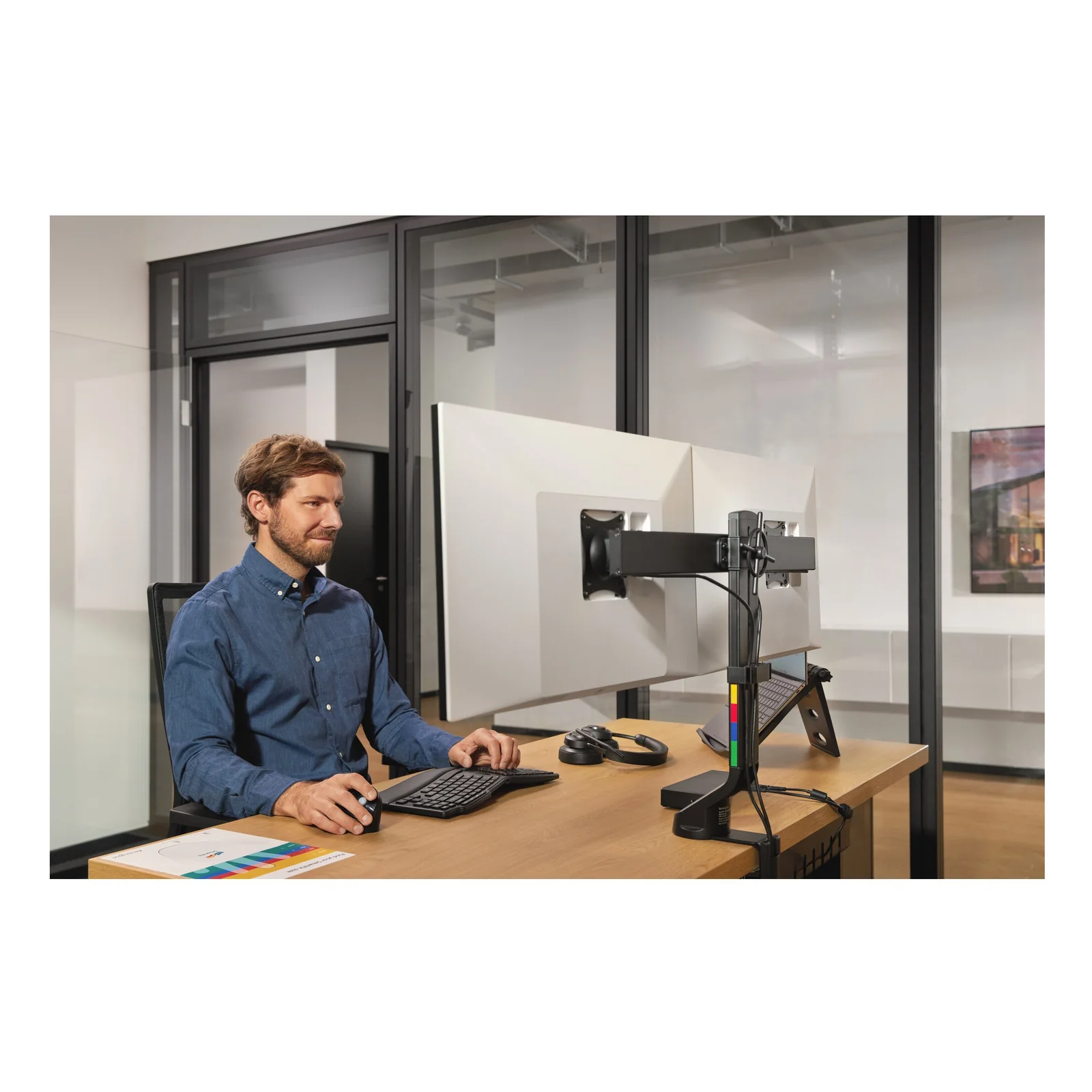 Homme réglant la hauteur d'un moniteur sur bras articulé de bureau