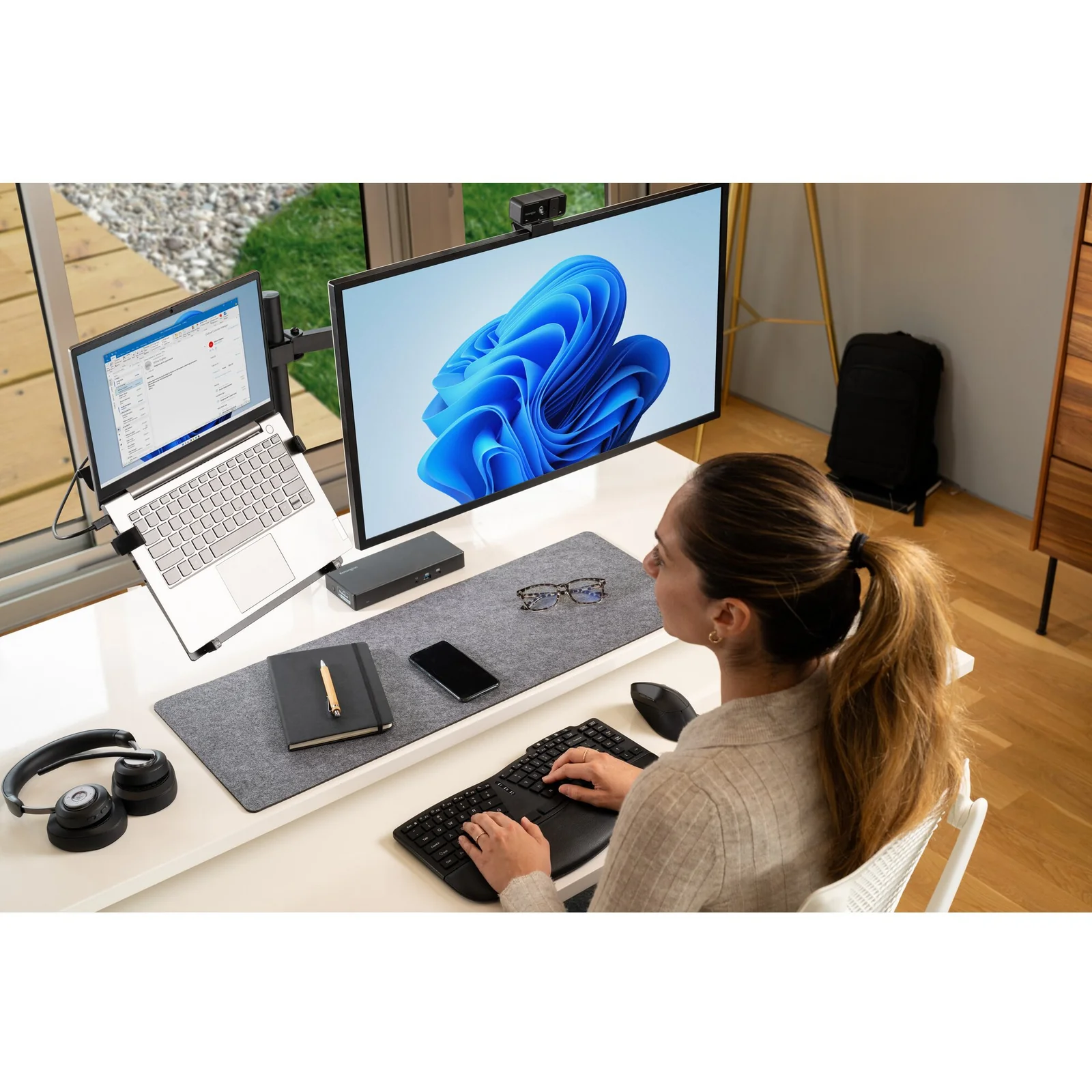 Femme face à un ordinateur portable avec station Kensington SD4781P et casque audio sur bureau