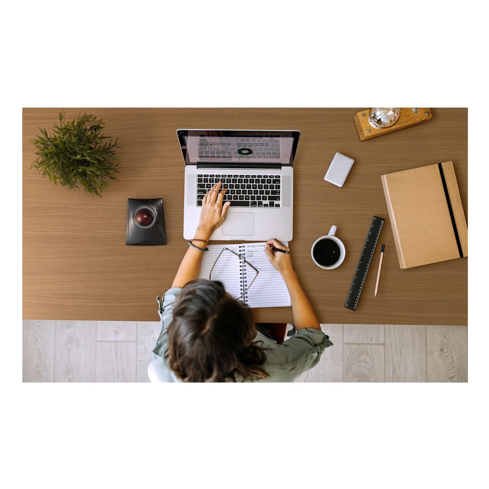 Vue aérienne, femme travaillant à un bureau avec ordinateur portable, trackball Kensington visible