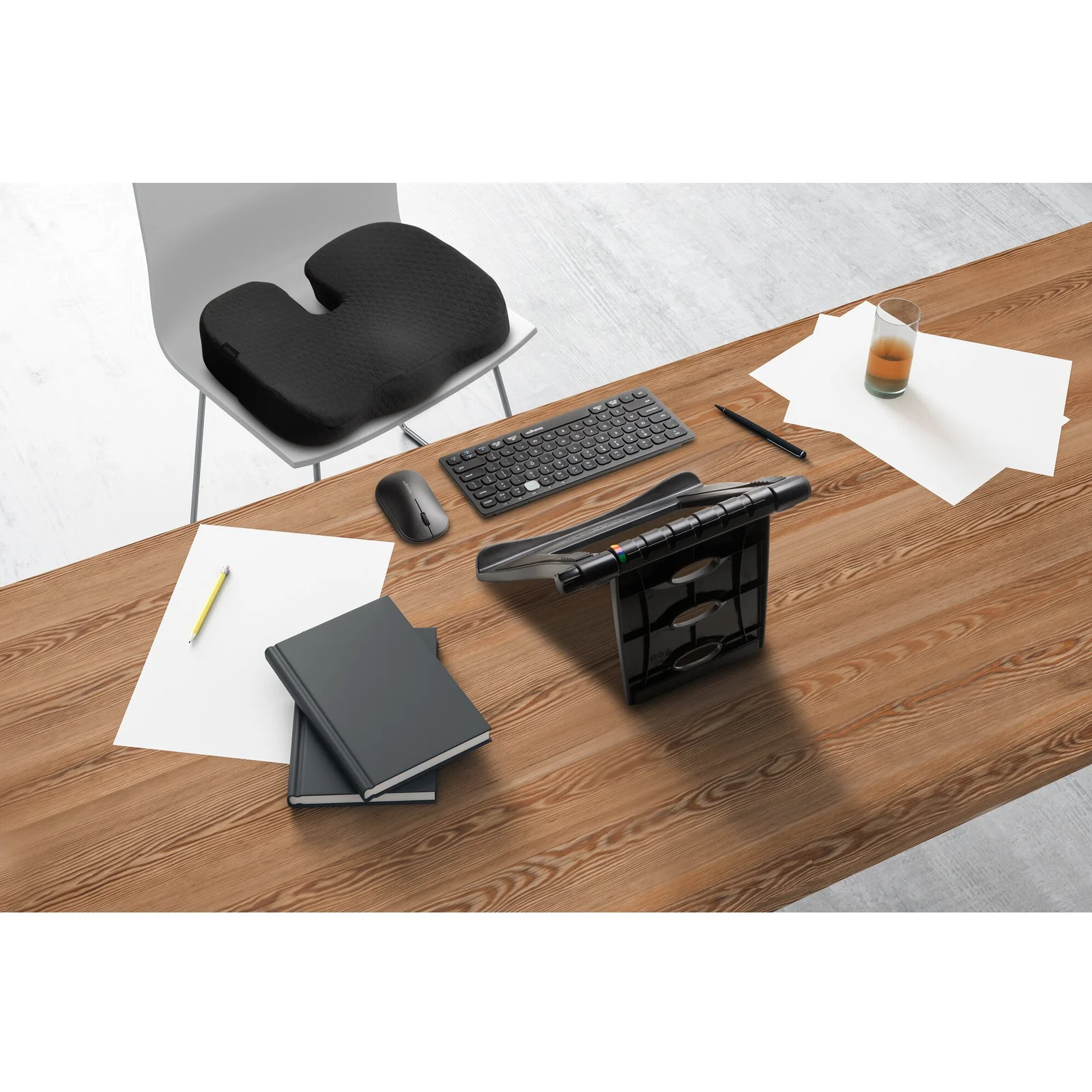 Bureau à domicile, laptop surélevé sur rehausseur noir, clavier et accessoires posés sur le plateau