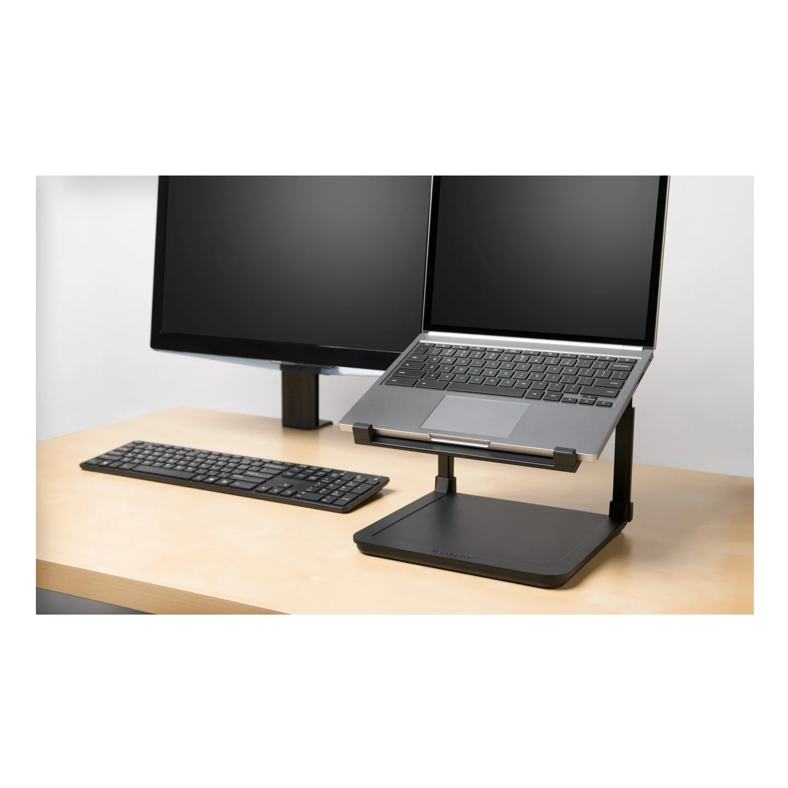 Rehausseur SmartFit sur bureau bois, portable surélevé et moniteur externe en arrière-plan