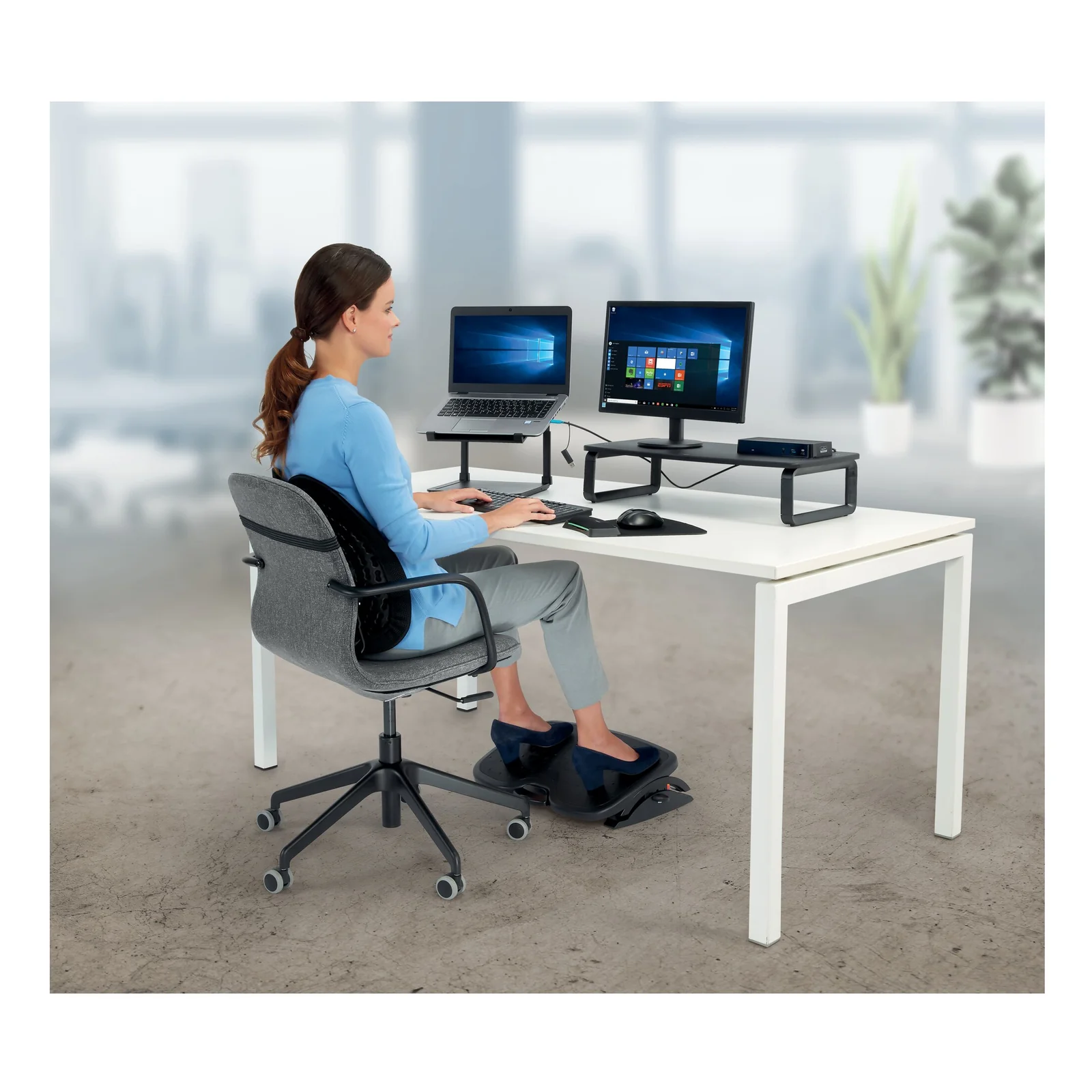 Femme assise au bureau avec rehausseur portable Kensington SmartFit, posture ergonomique