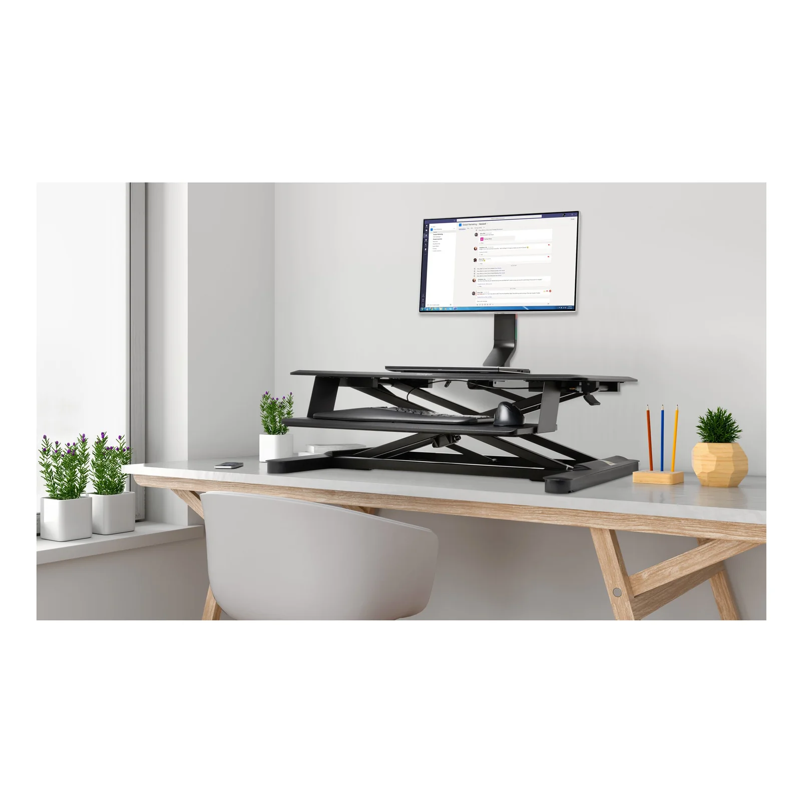 Bras SmartFit K55512WW supportant un grand écran sur bureau assis-debout en open space lumineux