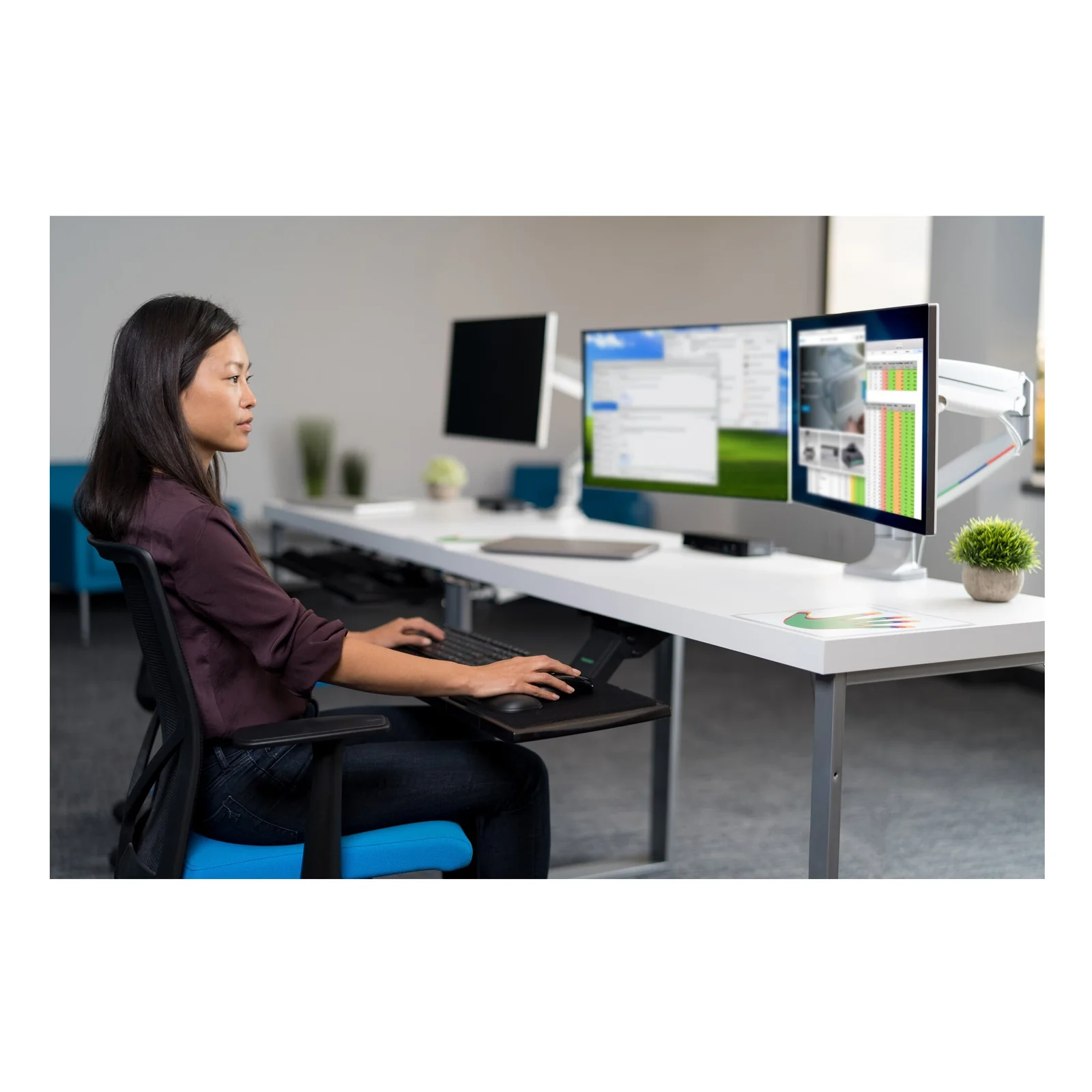 Collaboratrice assise à son bureau avec deux moniteurs sur bras Kensington SmartFit One-Touch