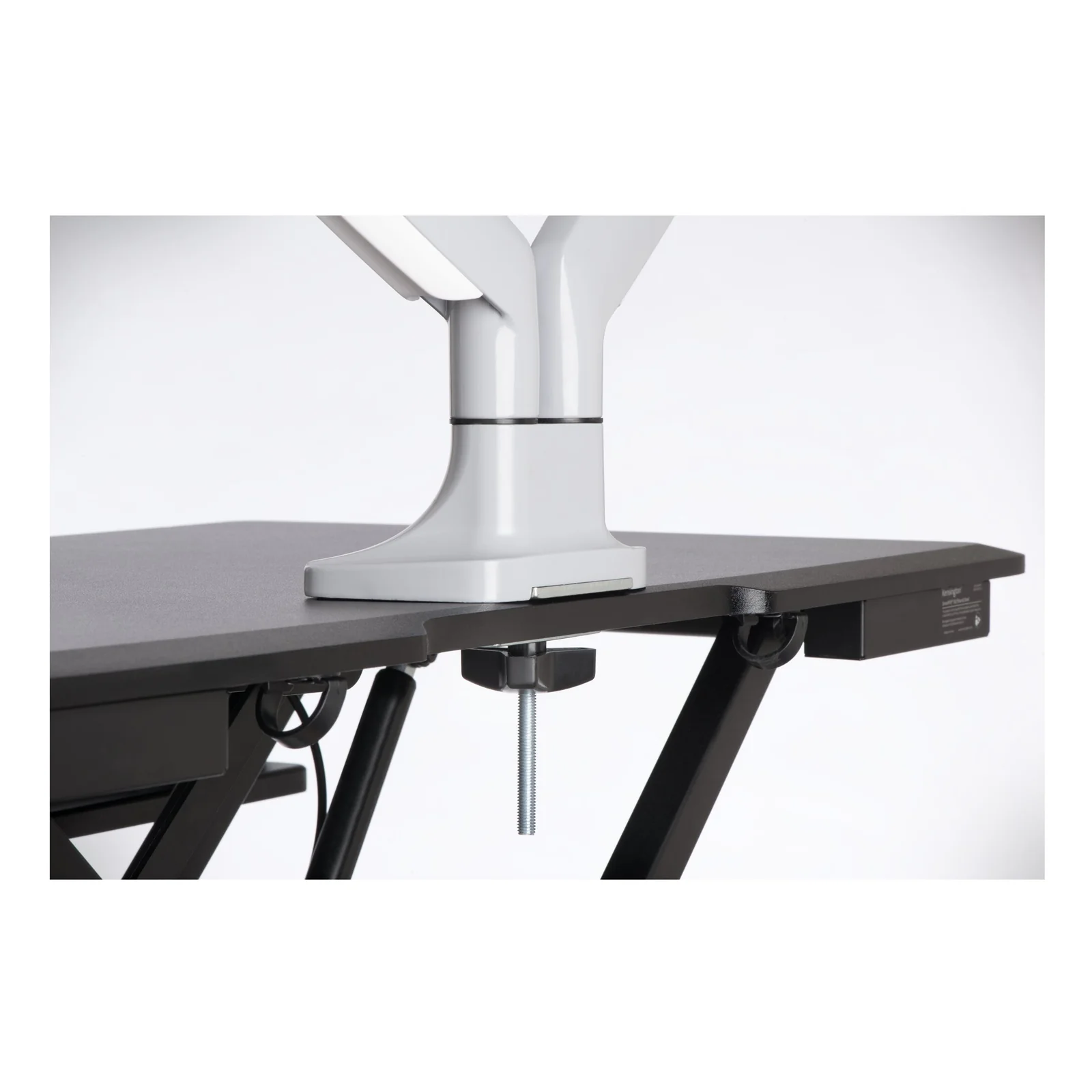 Gros plan sur la pince du bras Kensington K55471EU serrée sur bureau sombre, vue de face