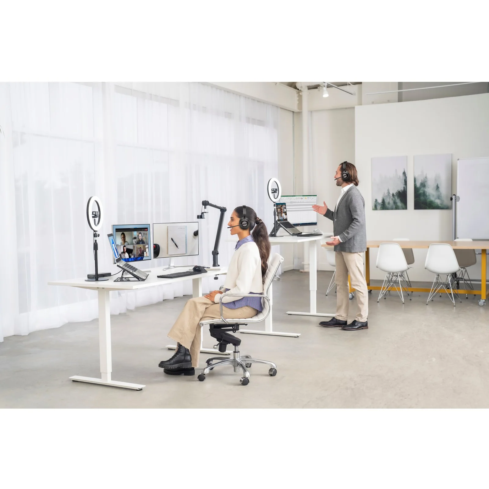 Open space avec bureaux réglables en hauteur et setup Kensington en arrière-plan