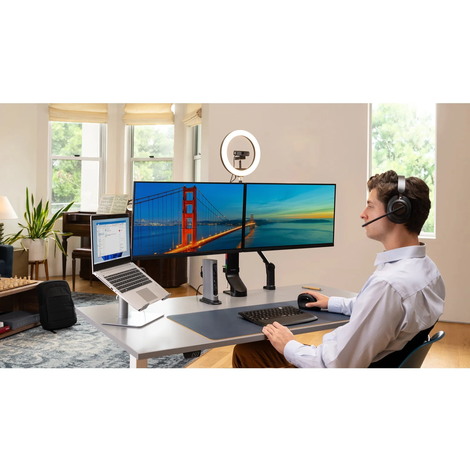 Personne au bureau avec double moniteur, casque audio et setup de travail complet