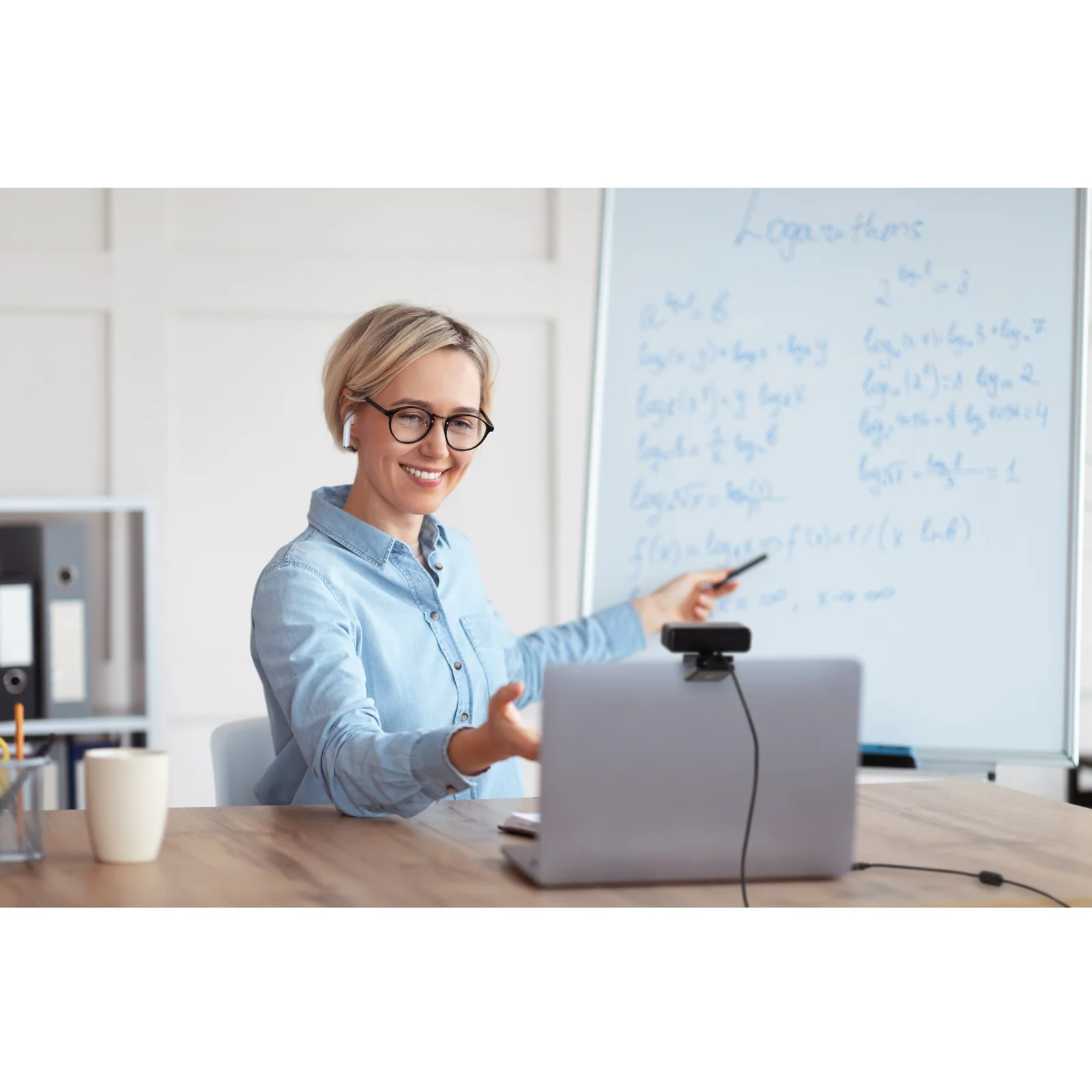 Femme en chemise bleue devant tableau blanc, présentation avec laptop et webcam W2050