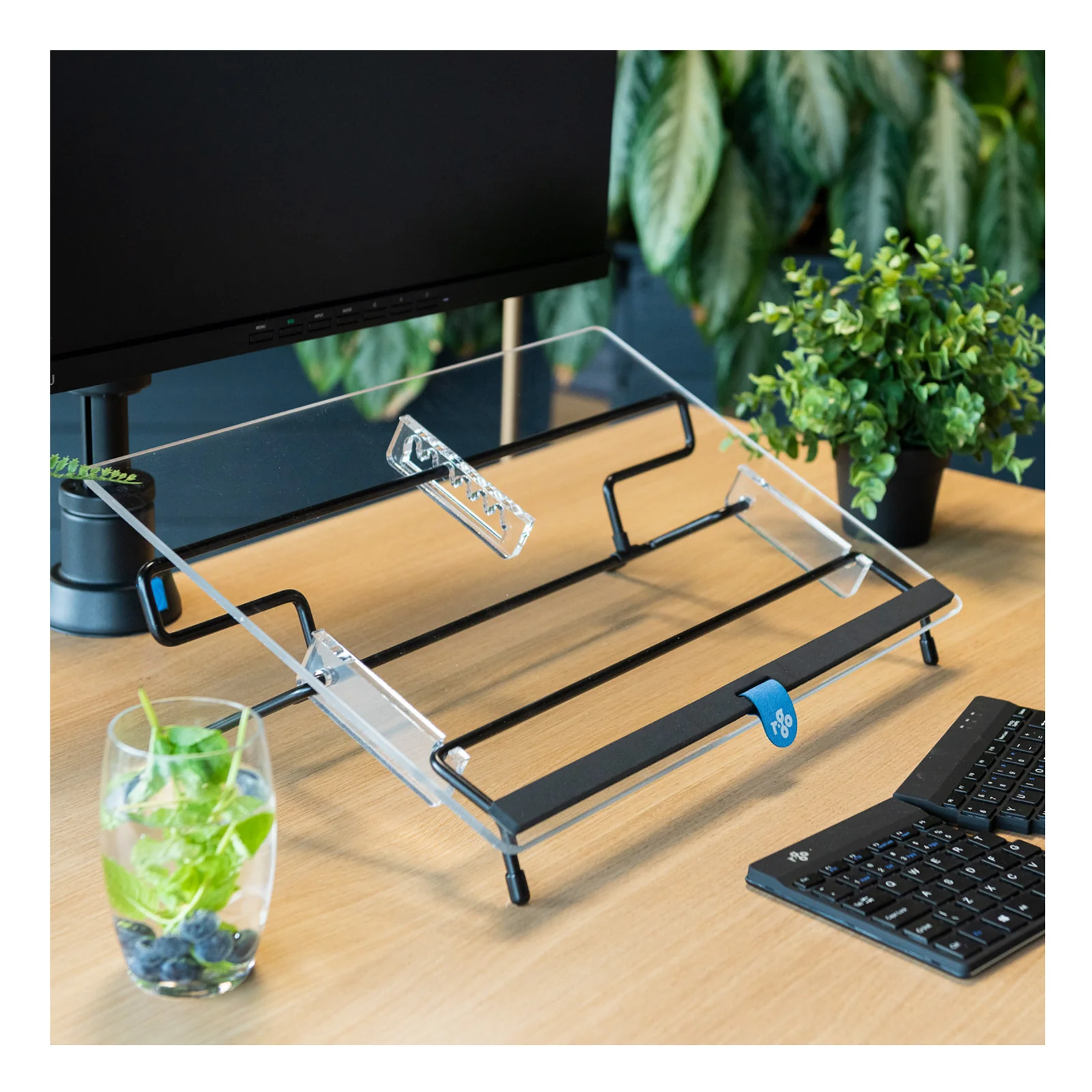 R-Go Flex Read sur bureau en bois, vue 3/4 côté, avec clavier en arrière-plan et plantes