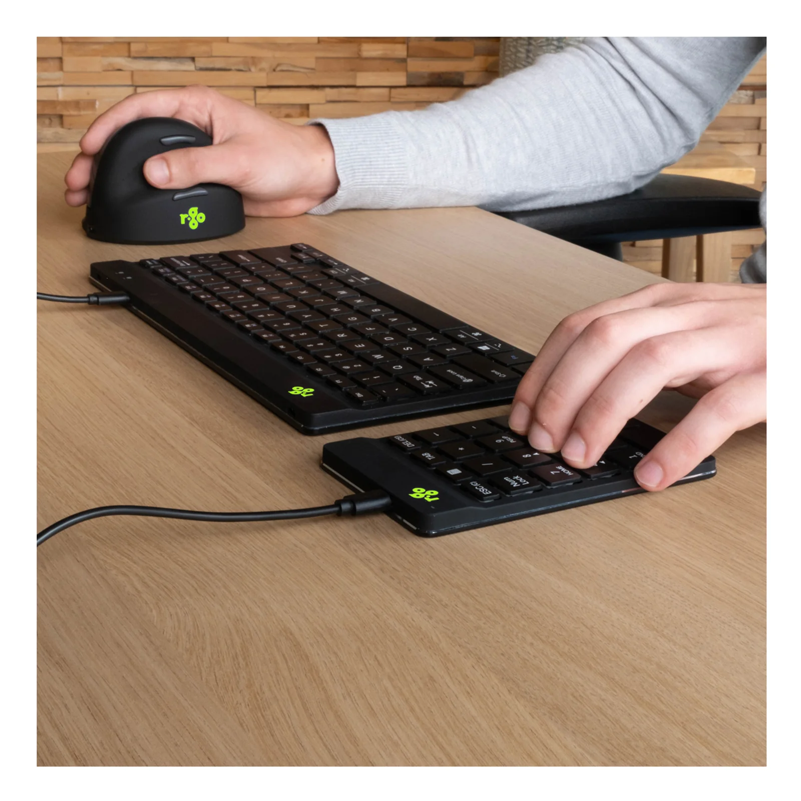 Pavé numérique posé à gauche d'un clavier noir sur bureau bois, souris verticale à droite