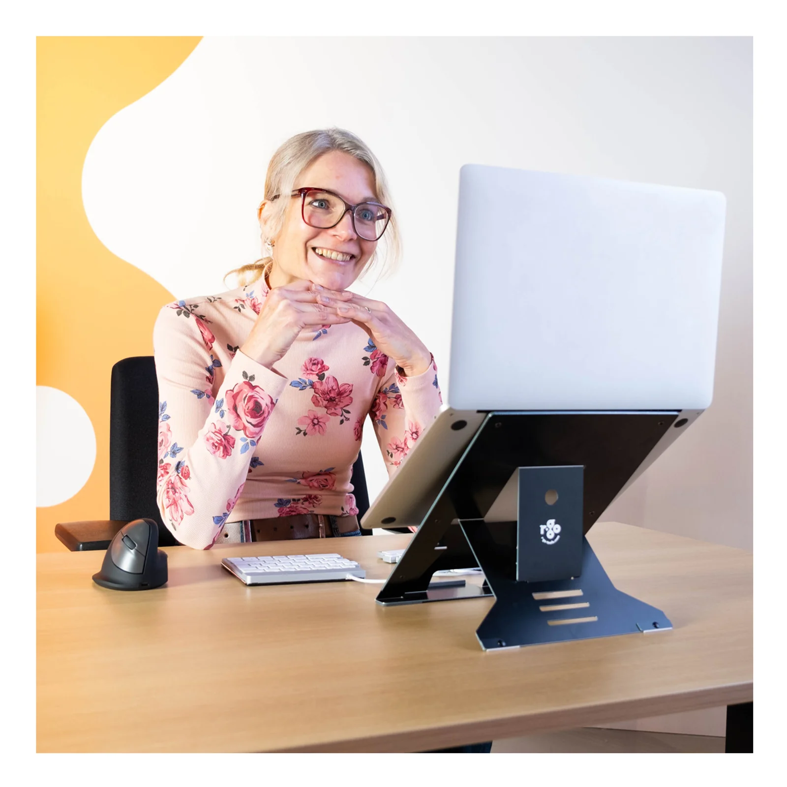 Femme au bureau avec laptop surélevé sur support R-Go Riser Document noir