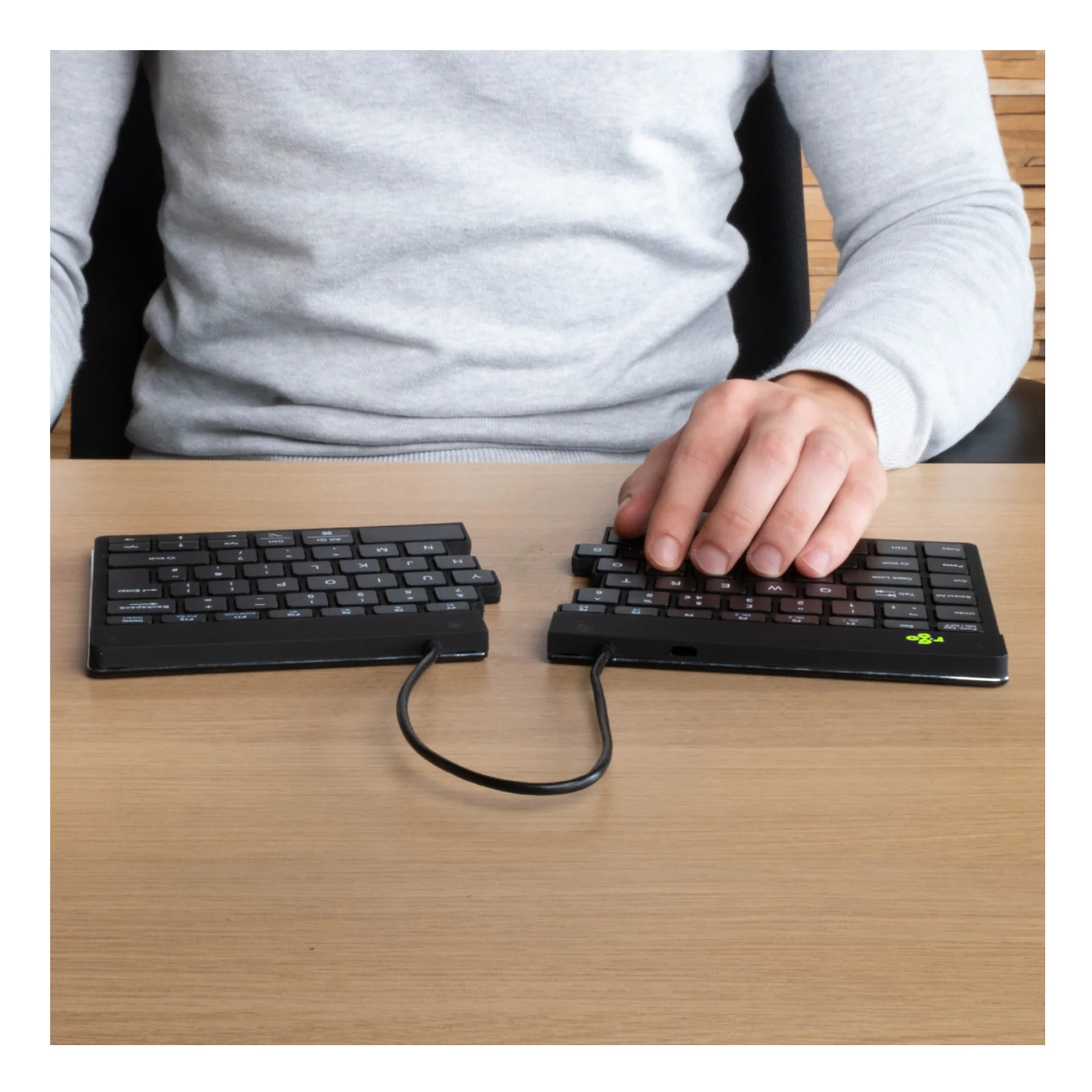 Personne en pull gris utilisant le R-Go Split Break, gros plan sur les mains
