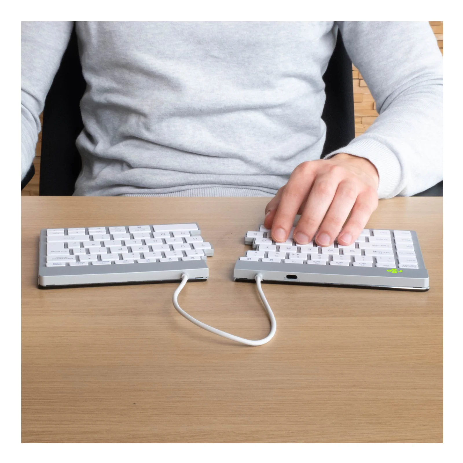 Personne tapant sur clavier R-Go Split Break blanc, vue depuis le dessus, bureau clair